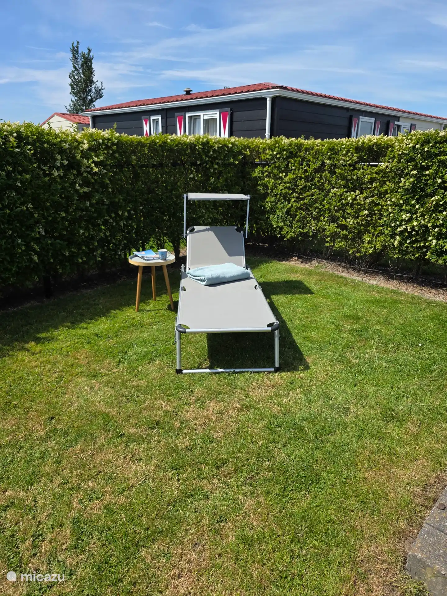 Omheind, privacy-beschermde tuin met een comfortabele ligstoel - perfect voor ontspanning en privé-uren
