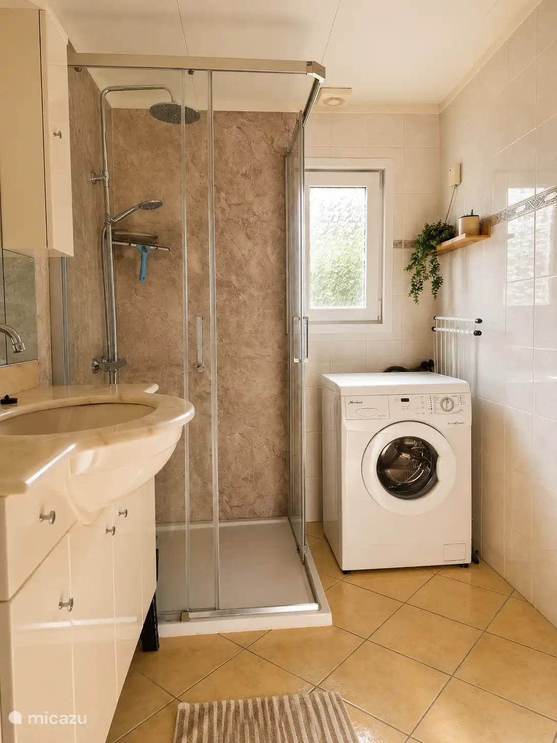 De fijne badkamer mét regendouche en wasmachine. 