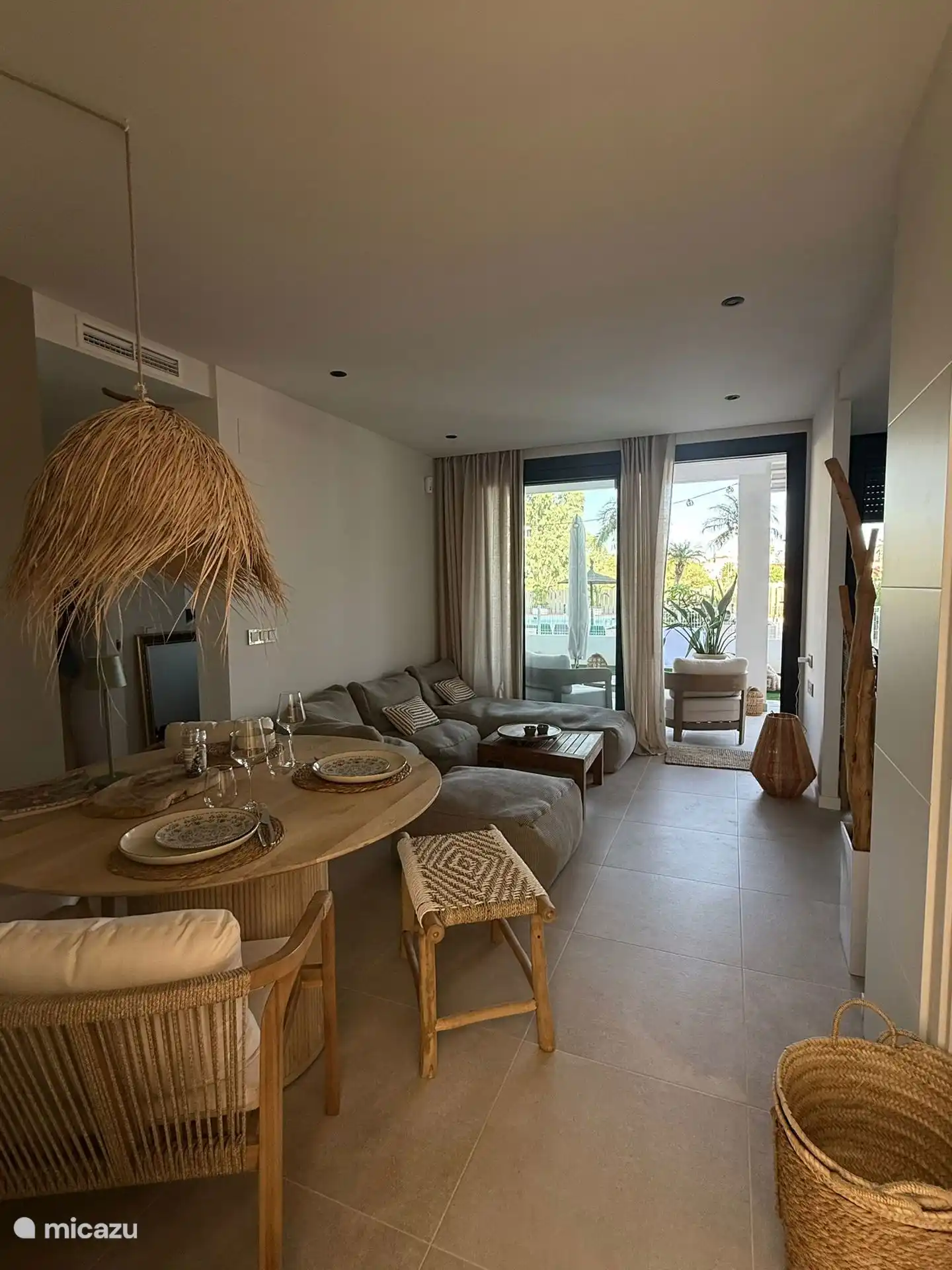 Vista desde el comedor hacia la zona de estar y la terraza con la piscina detrás.