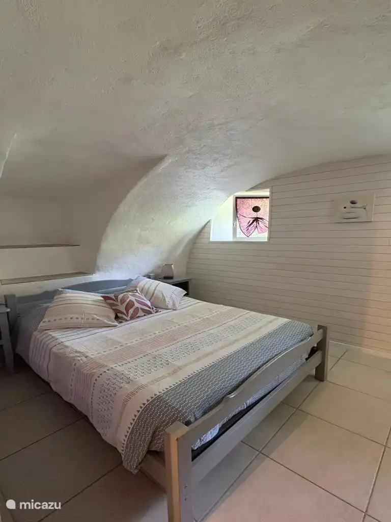 Een intieme en warme slaapruimte onder het stenen gewelf van het gebouw.