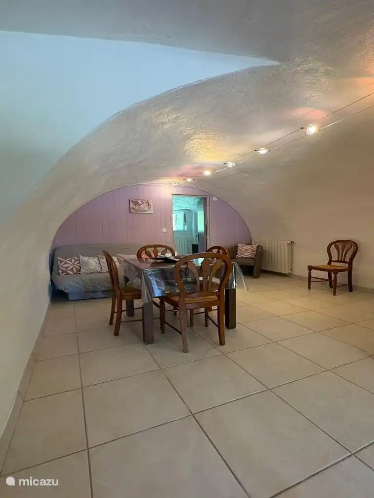 Gezellige woonkamer onder het gewelf met eet- en loungeruimte om samen te komen.