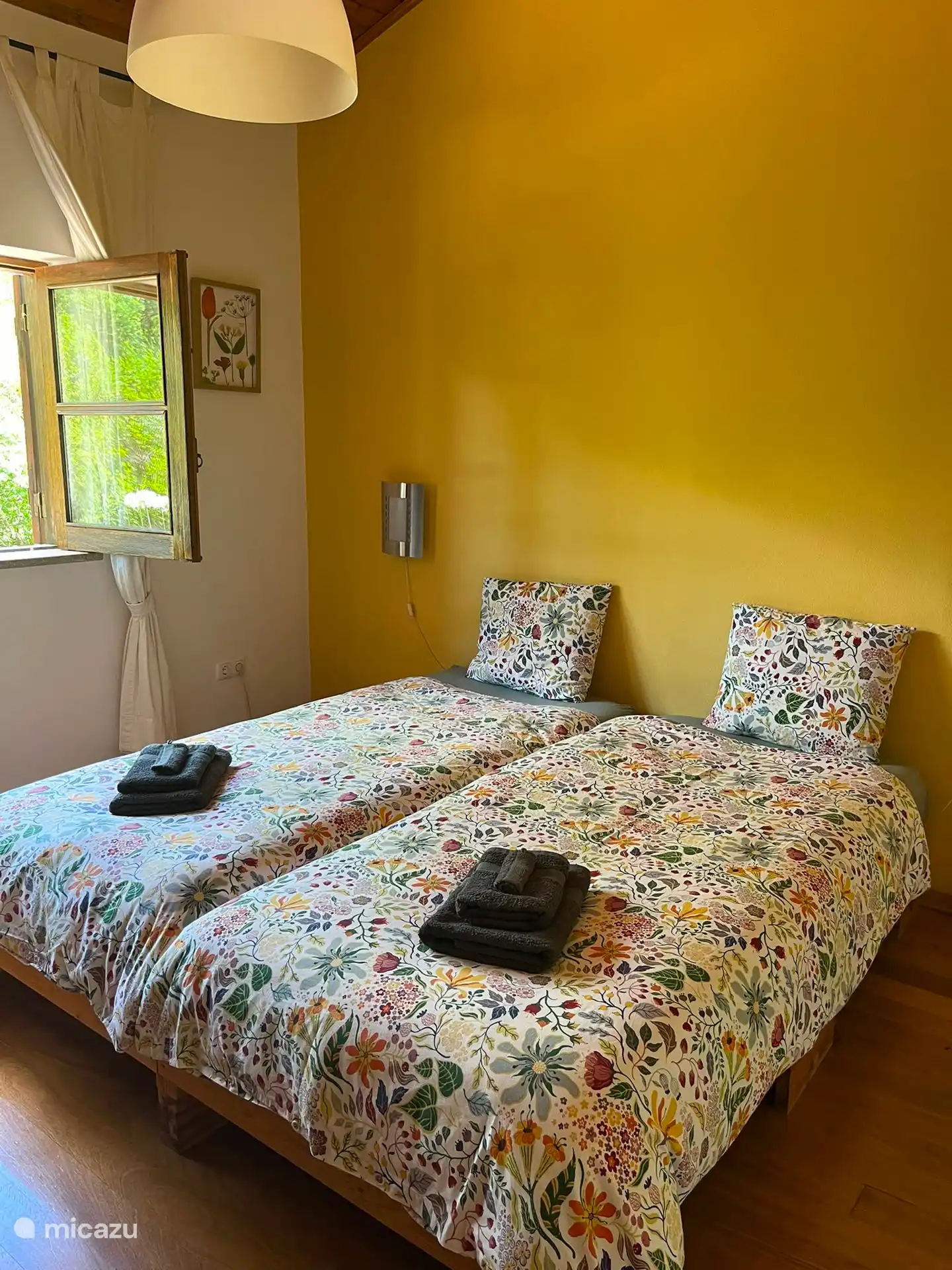 Sfeervolle slaapkamer met tweepersoonsbed en uitzicht op het groen