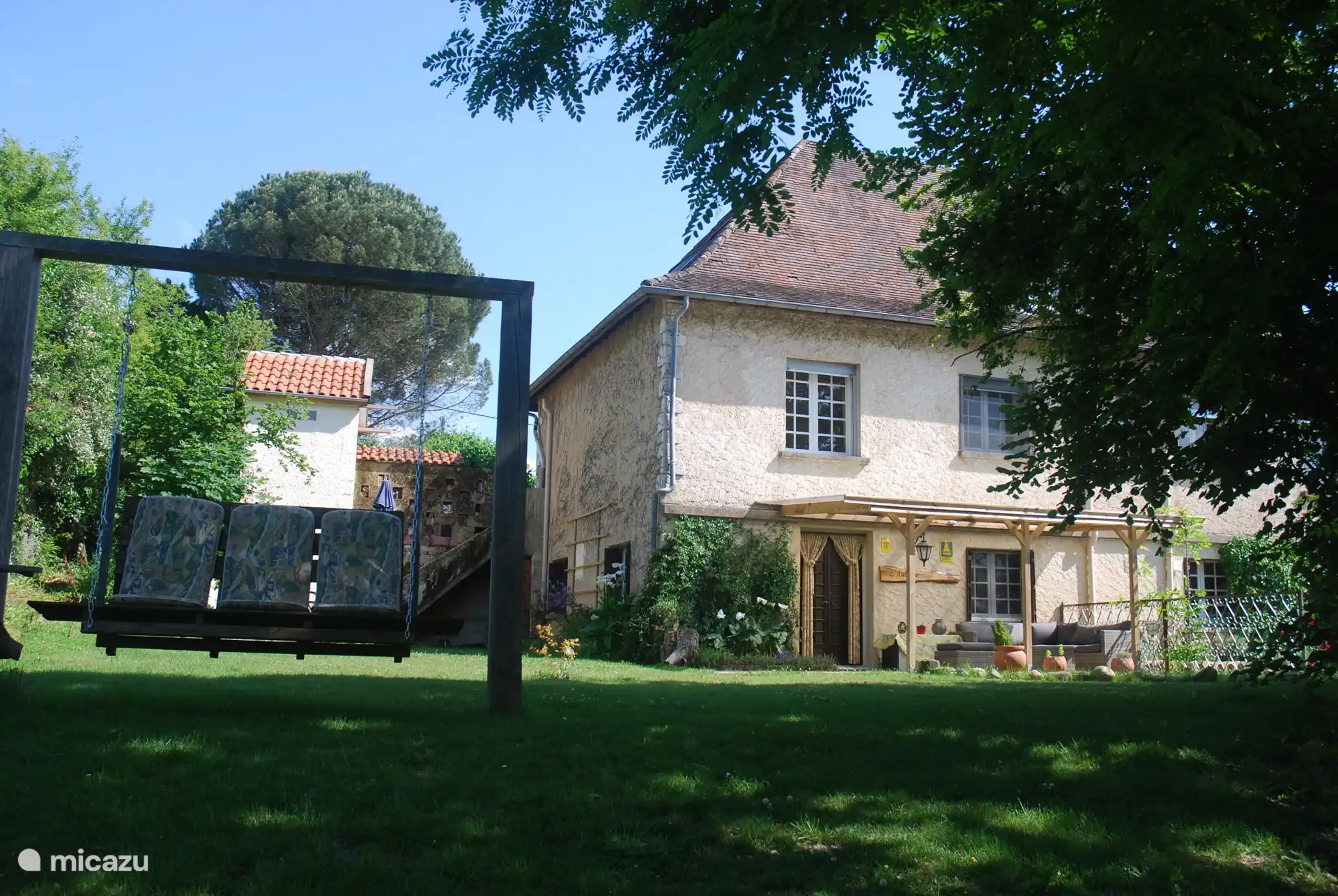 De privétuin van de gîte, met schommelbank