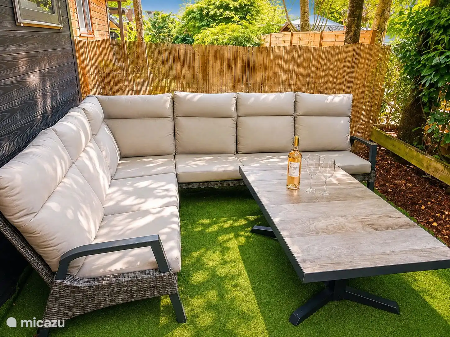 Comfortabele loungehoek in de tuin met veel privacy. De perfecte plek om te ontspannen, te genieten van een drankje en tot rust te komen in een groene omgeving.