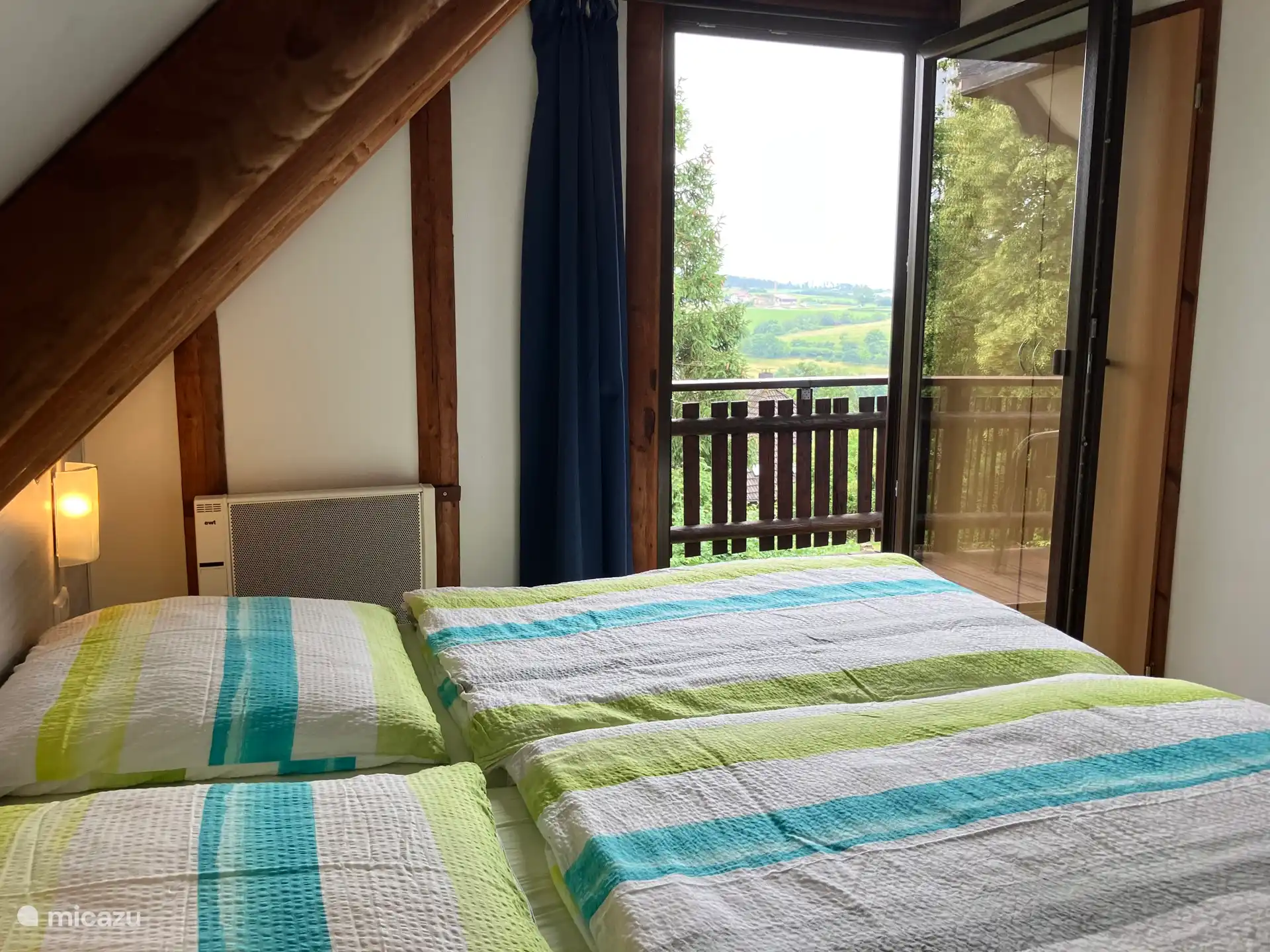 Comfortabele bedden aangrenzend aan het balkon met bijzonder uitzicht over de heuvels en weidevelden van Frankenau.