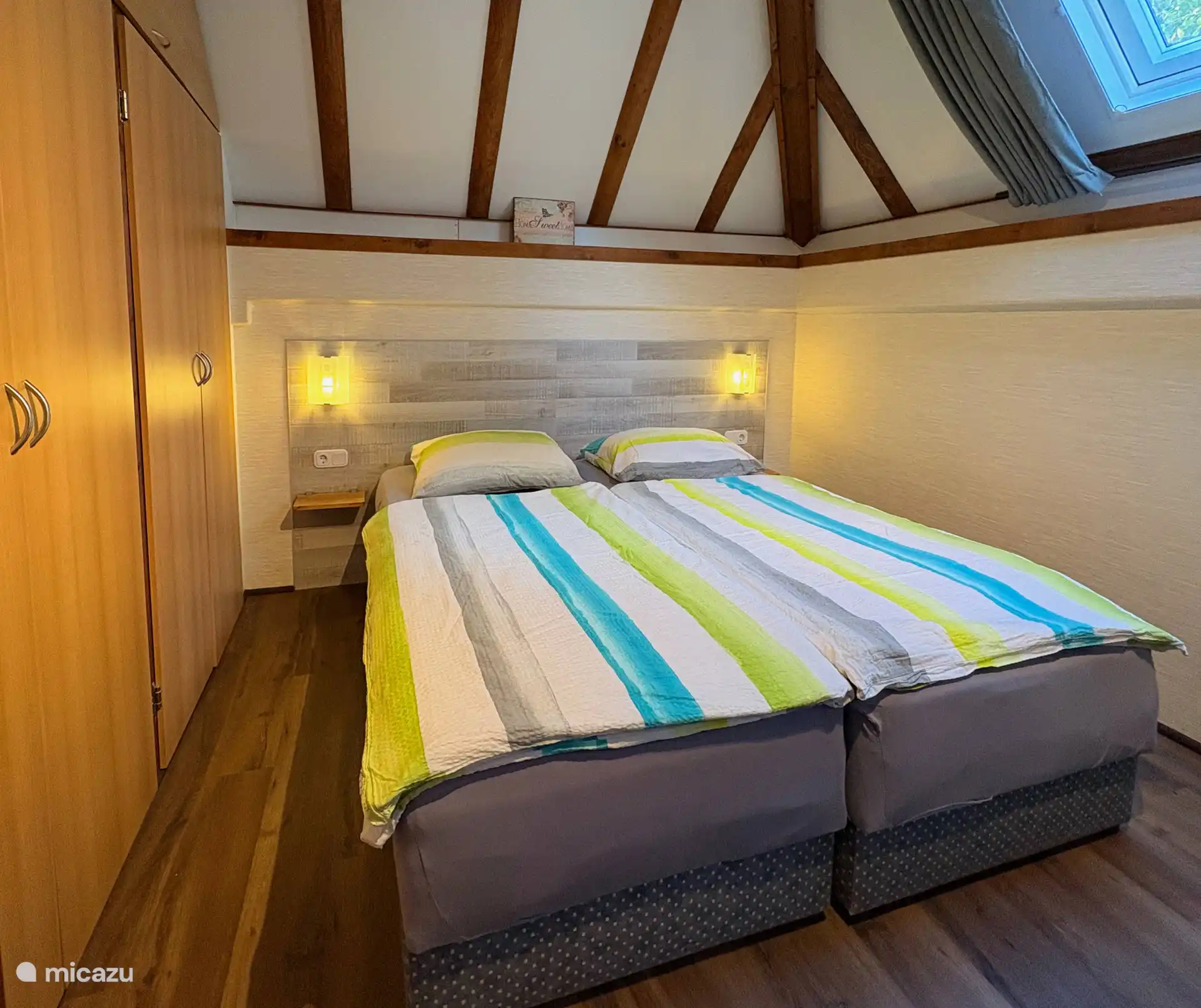 Slaapkamer beneden met comfortabele bedden en eigen toiletruimte met wastafel.
