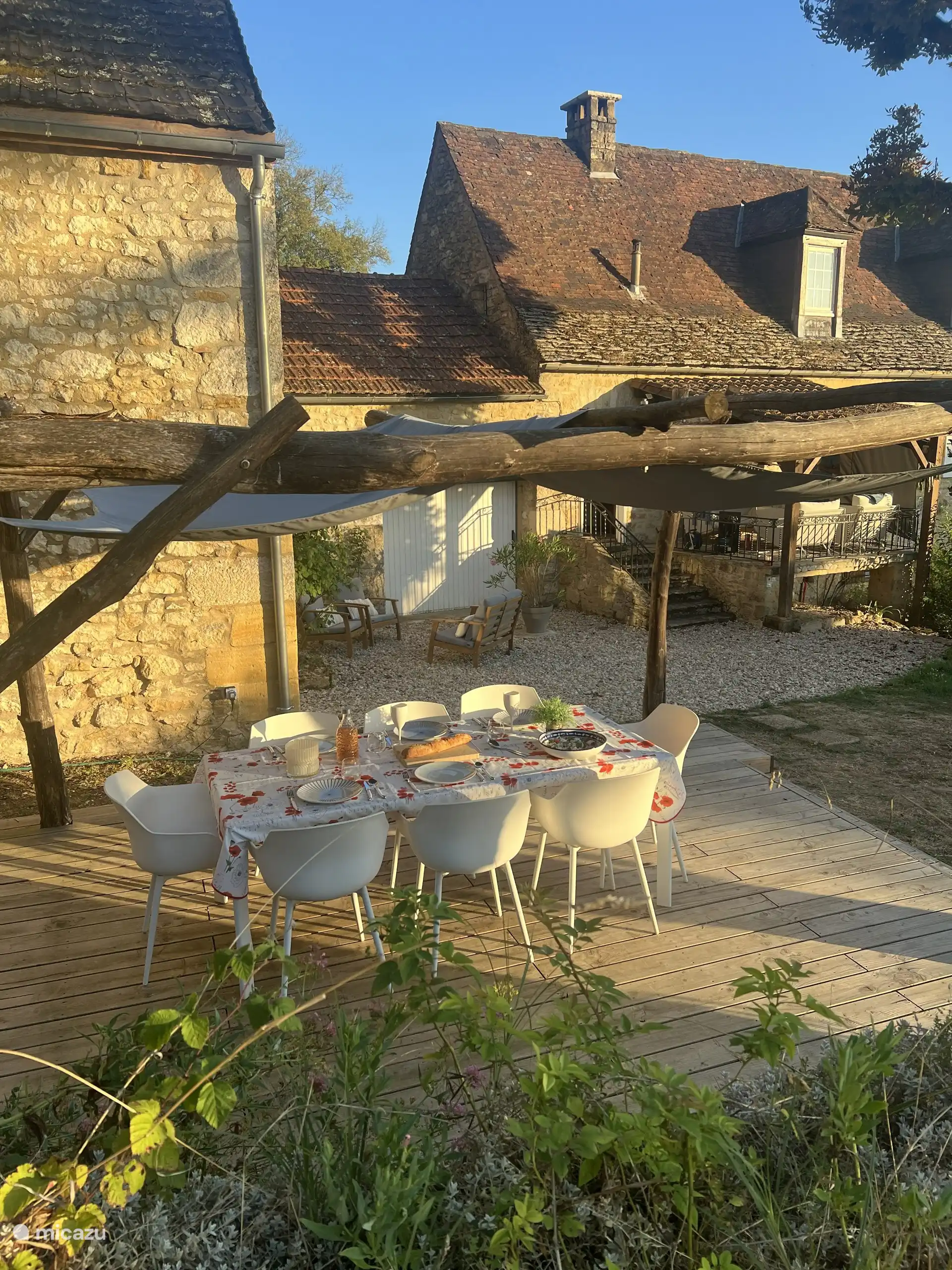 Comedor al aire libre bajo la pérgola, con vistas al jardín