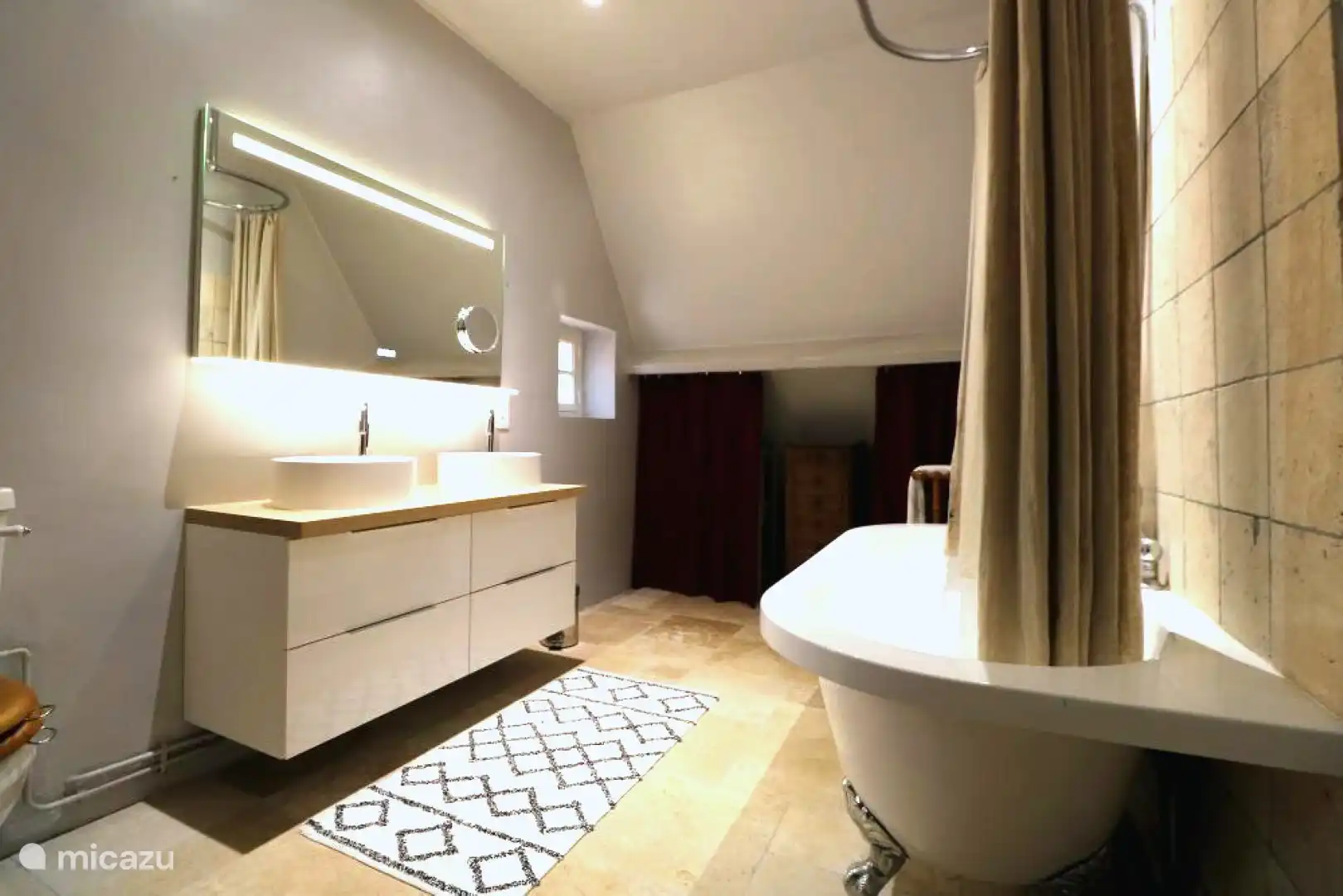 El baño de la primera planta, con bañera independiente y lavabo doble.