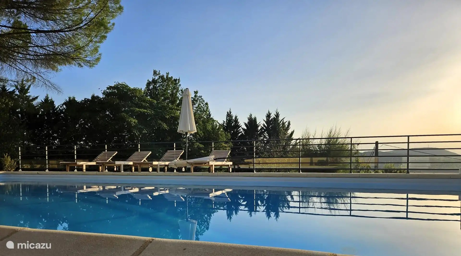 La piscina privada bajo el sol de la tarde, con tumbonas para un momento tranquilo tras un día caluroso.