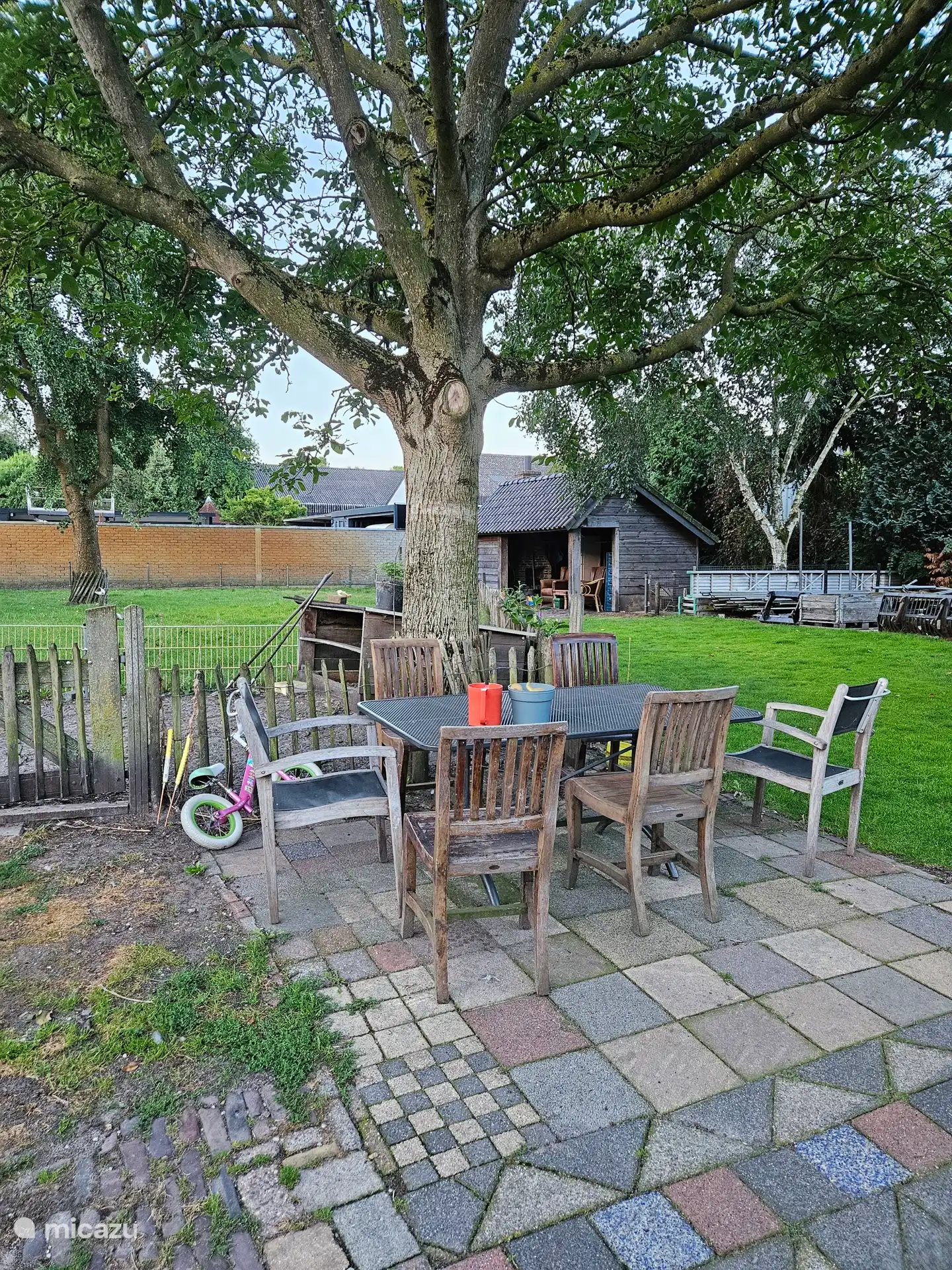 Het zitje onder de notenboom achter in de tuin, waar je vrij gebruik van mag maken.