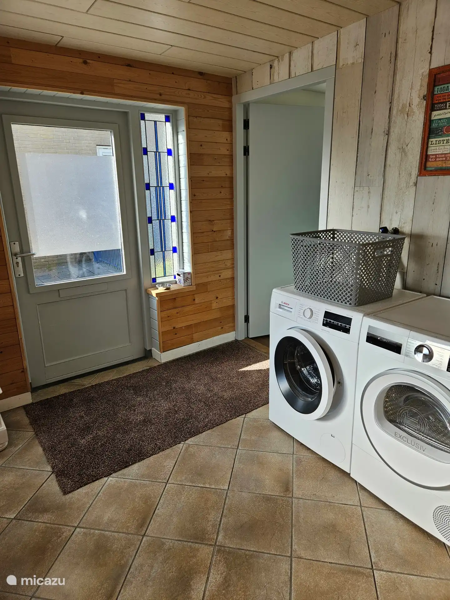 Schuurtje met wasmachine en droger, buitendeur en rechts de deur naar de gang met slaapkamers.