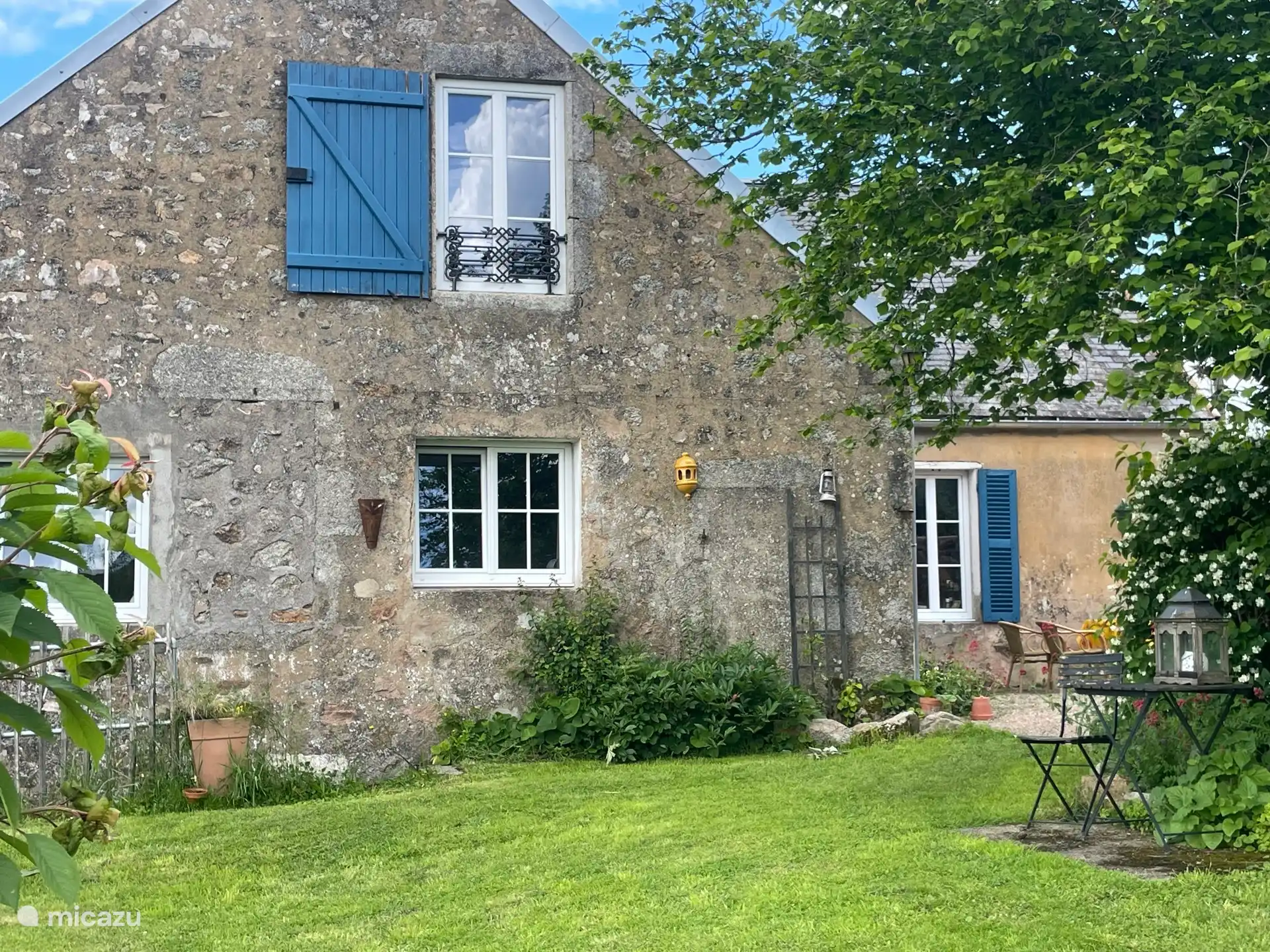 Zicht op huis vanuit de ruime ommuurde tuin