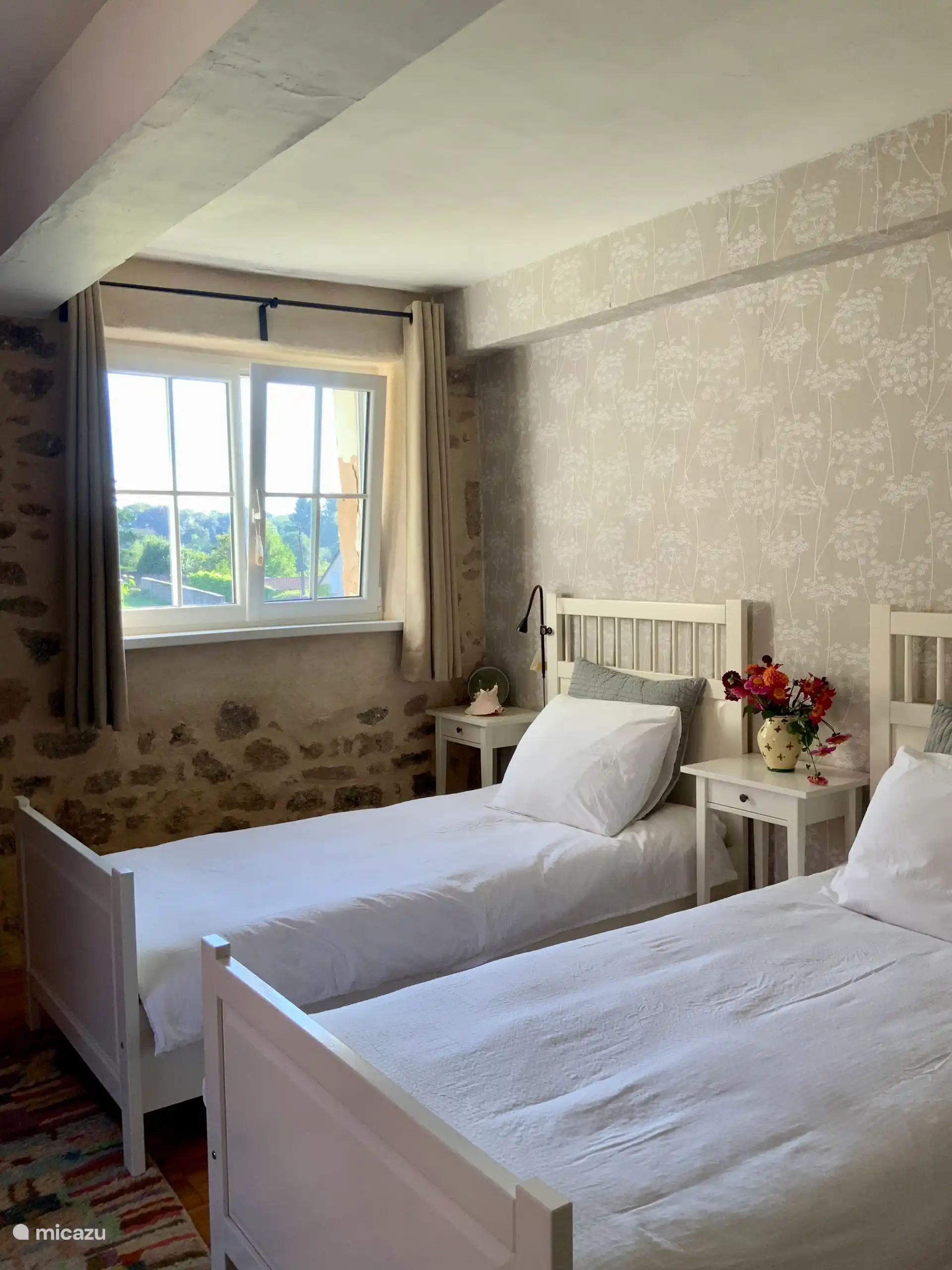 Slaapkamer aan tuinkant met twee eenpersoons bedden 