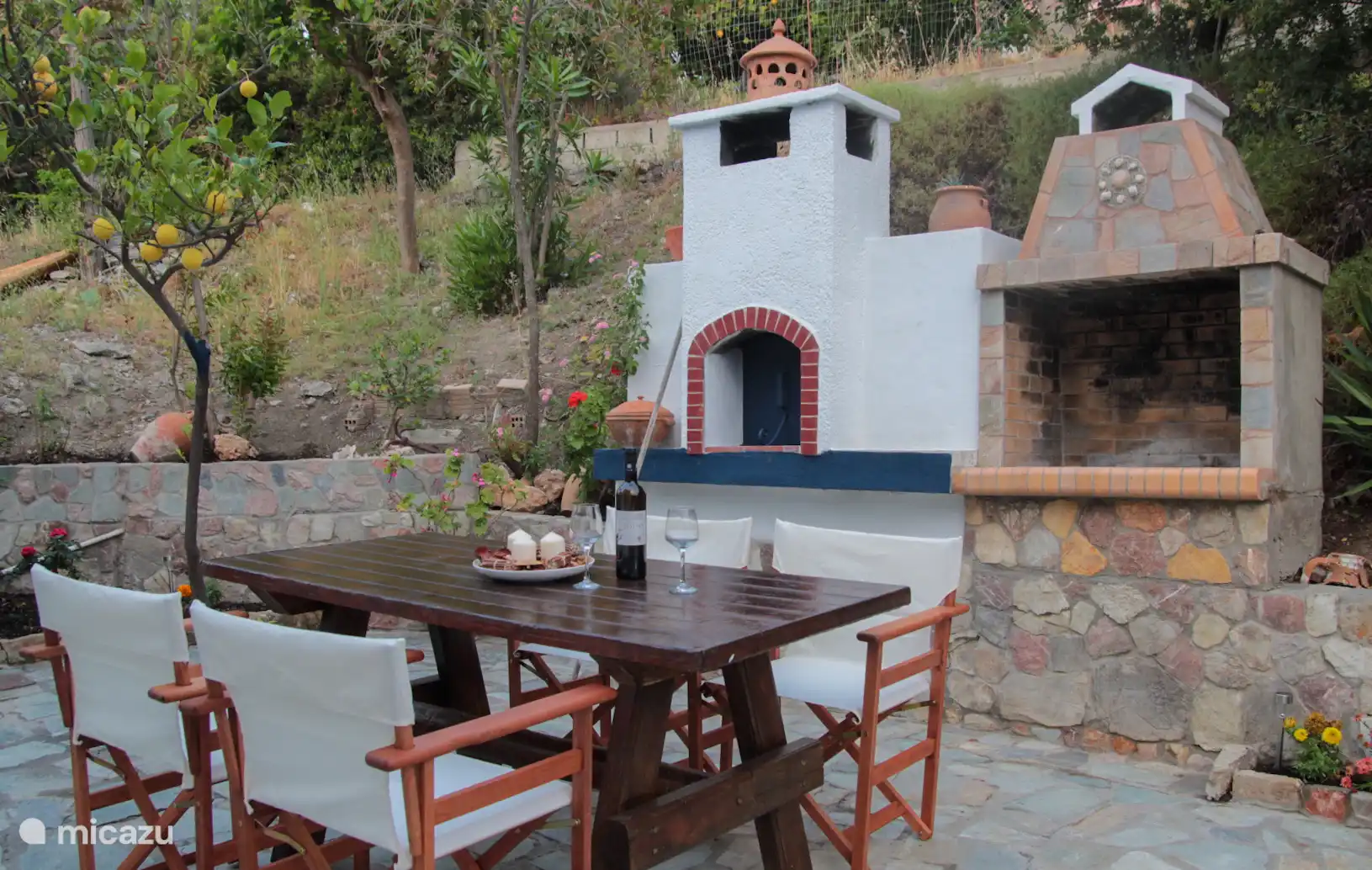 Patio trasero de la villa con el tradicional horno de leña y zona de barbacoa