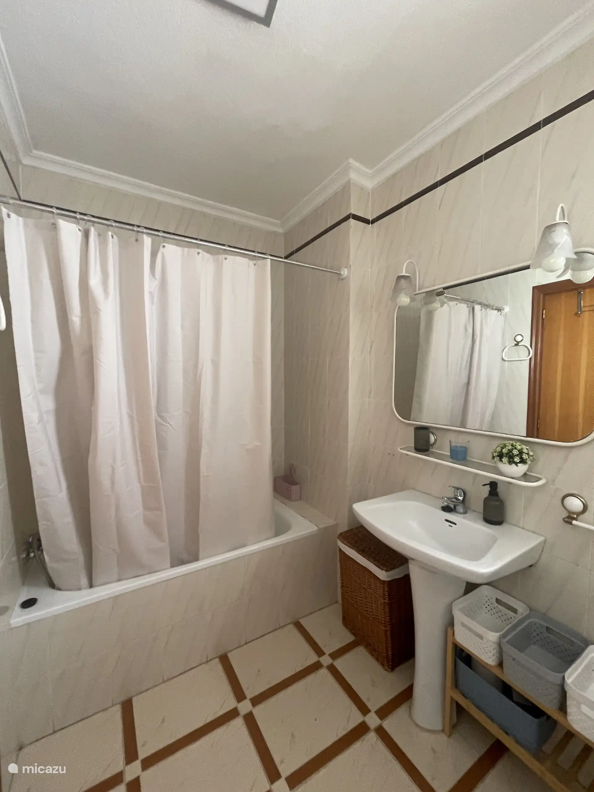 Une autre perspective de la salle de bain complète, montrant la baignoire, le lavabo et le miroir.