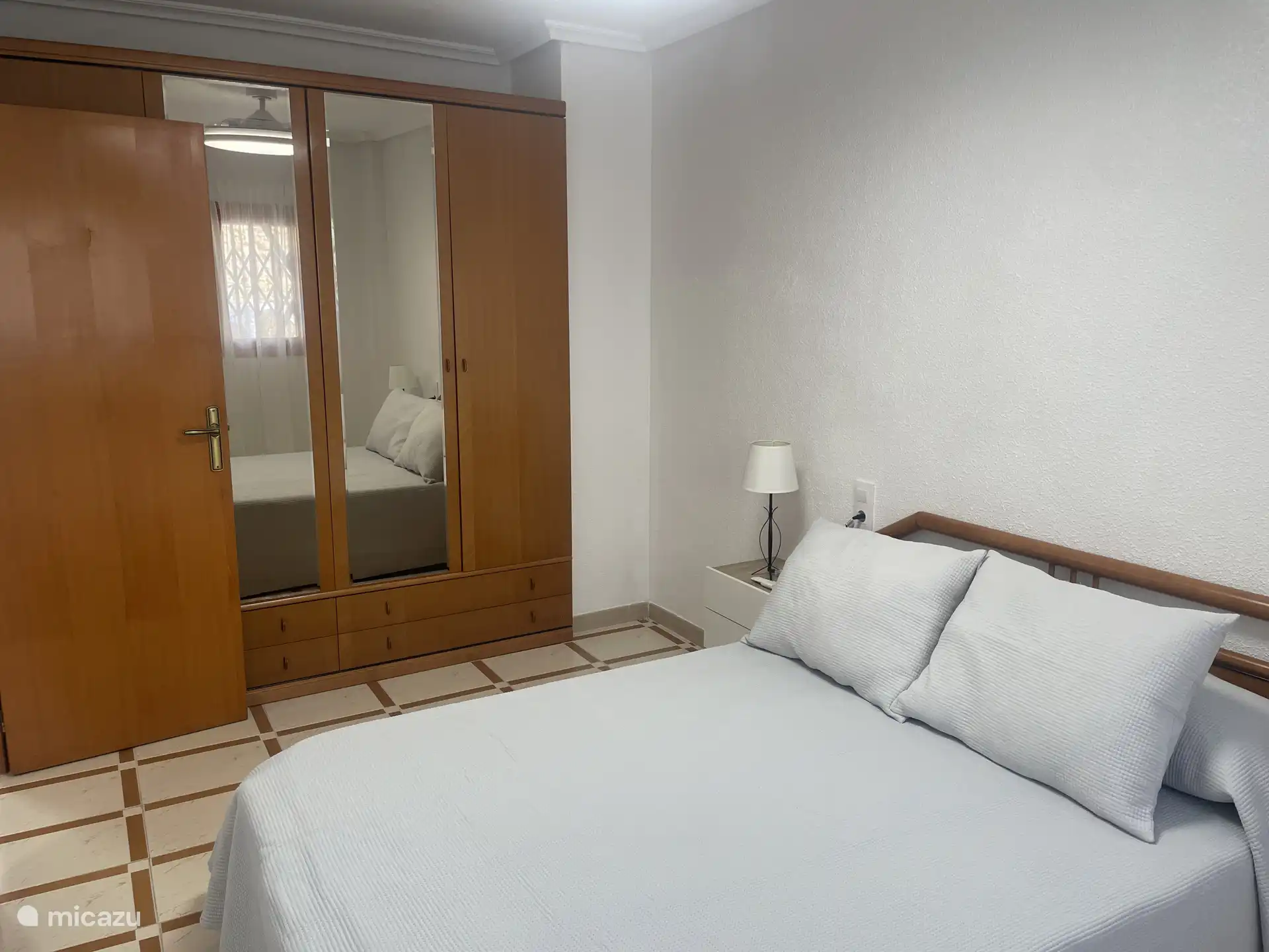 Une autre perspective de la chambre parentale, montrant le lit double et la garde-robe.