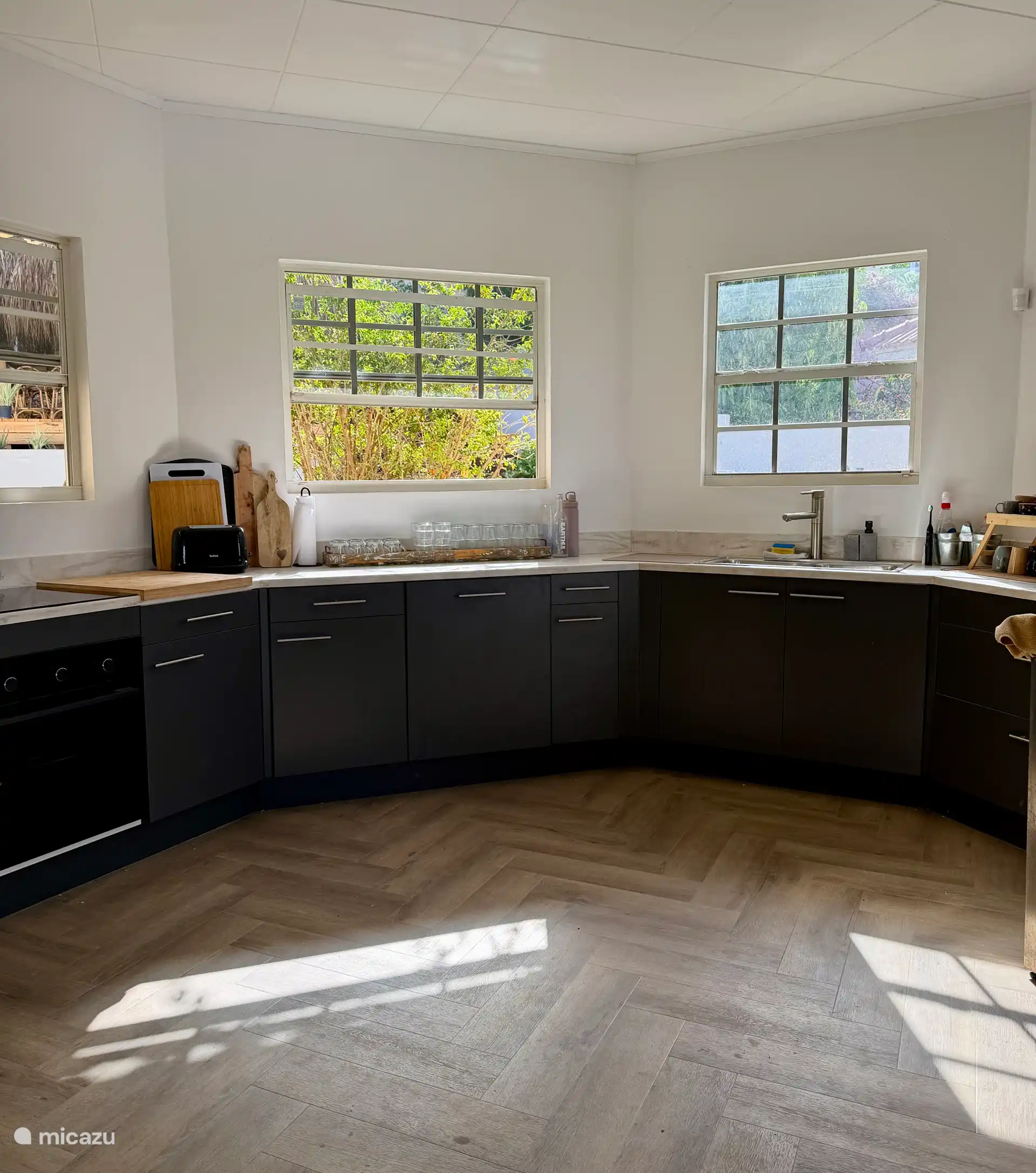 Magnifique cuisine ronde ouverte avec réfrigérateur américain, cafetière Nespresso, four et plaque à induction.