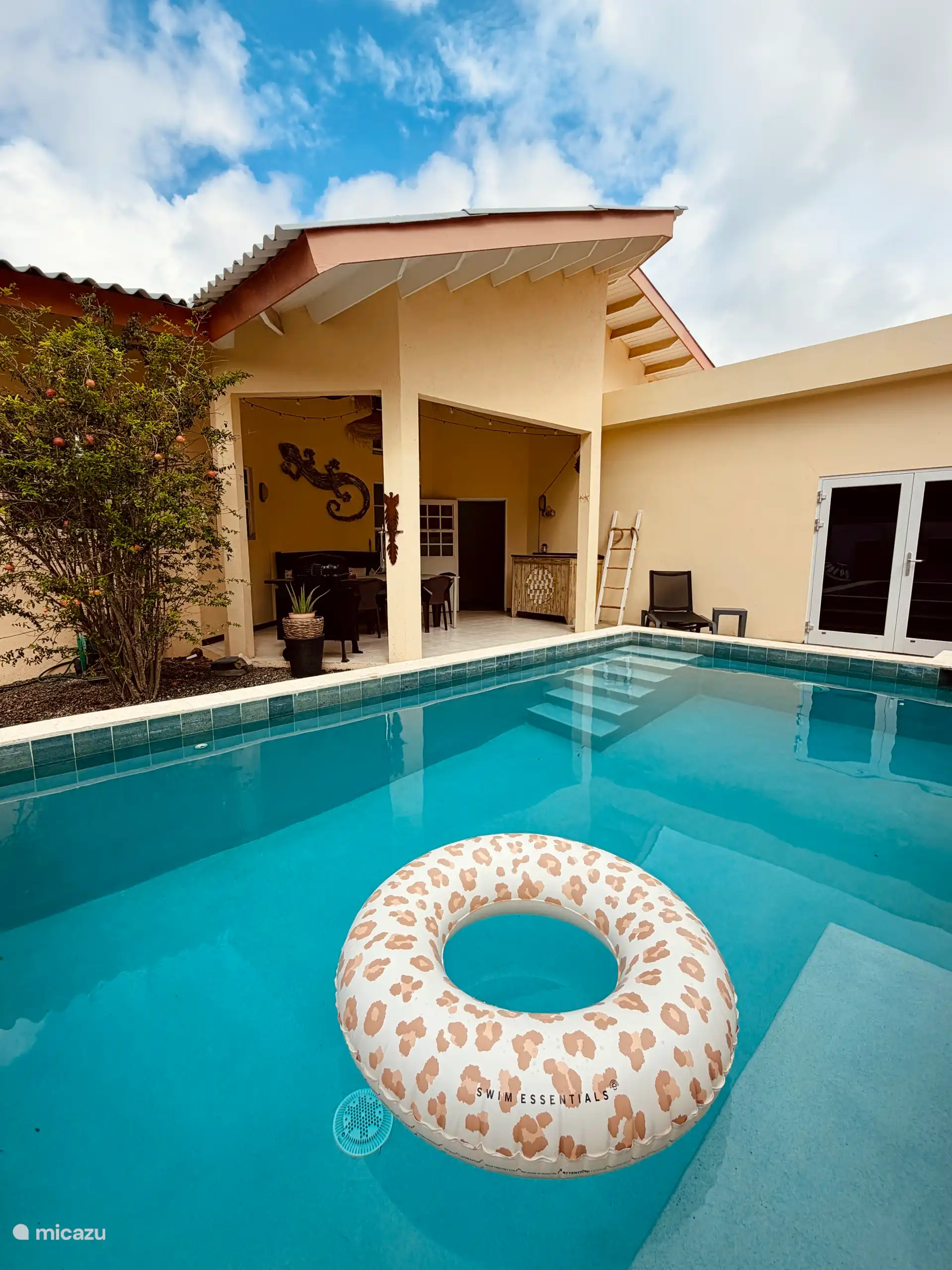 Piscine privée avec plusieurs espaces de repos et des transats.