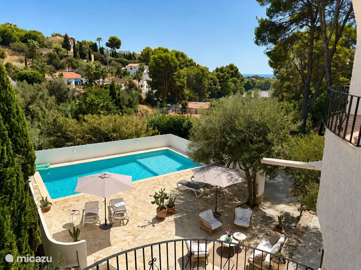 Vue sur la piscine, la terrasse et, en arrière-plan, la mer depuis l’extérieur des escaliers