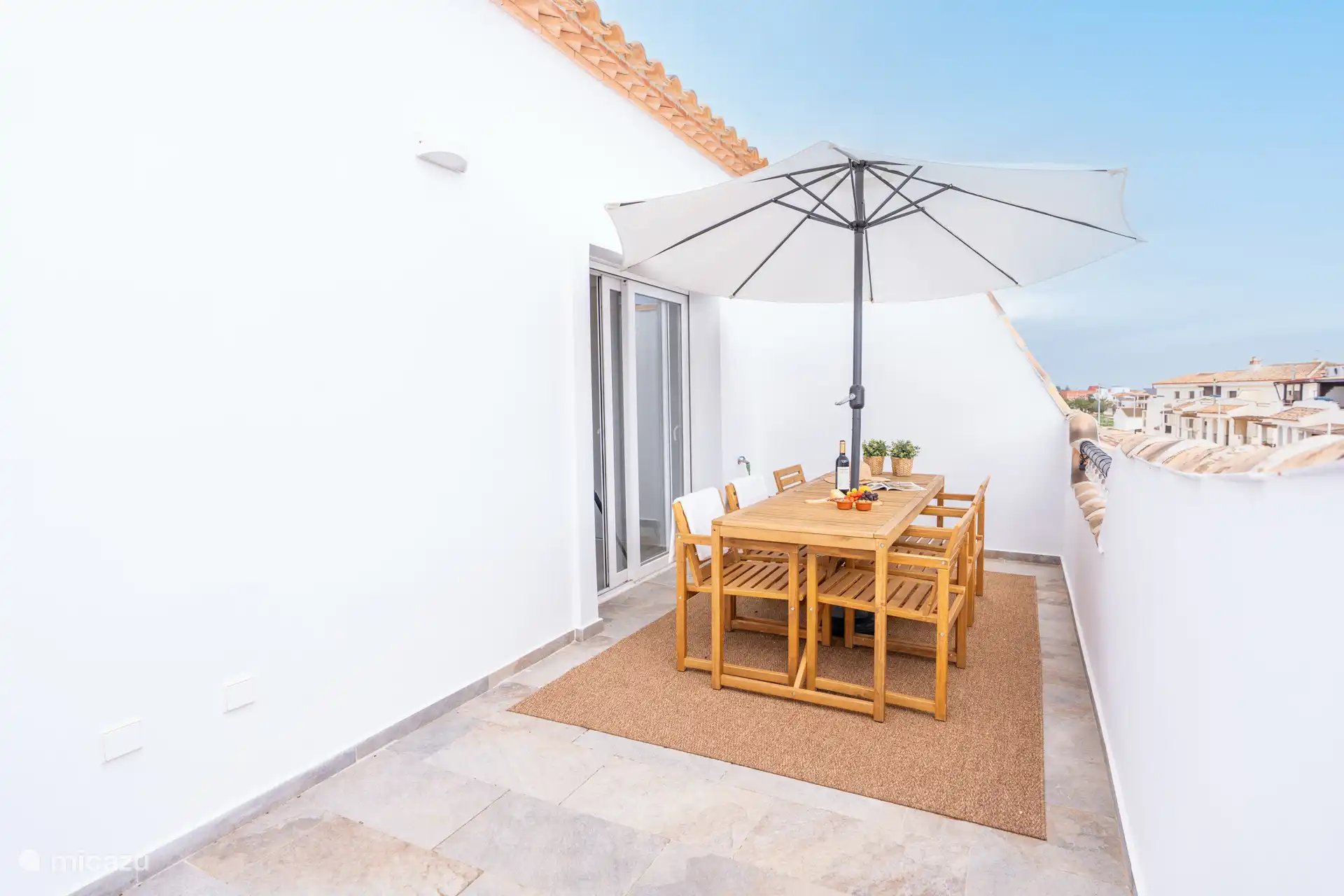 Terrasse privée sur le toit avec un coin à manger chaleureux.