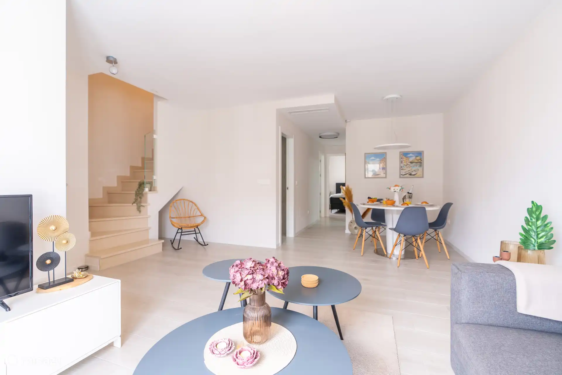 Salon avec escaliers et accès à une cuisine et une chambre séparées.