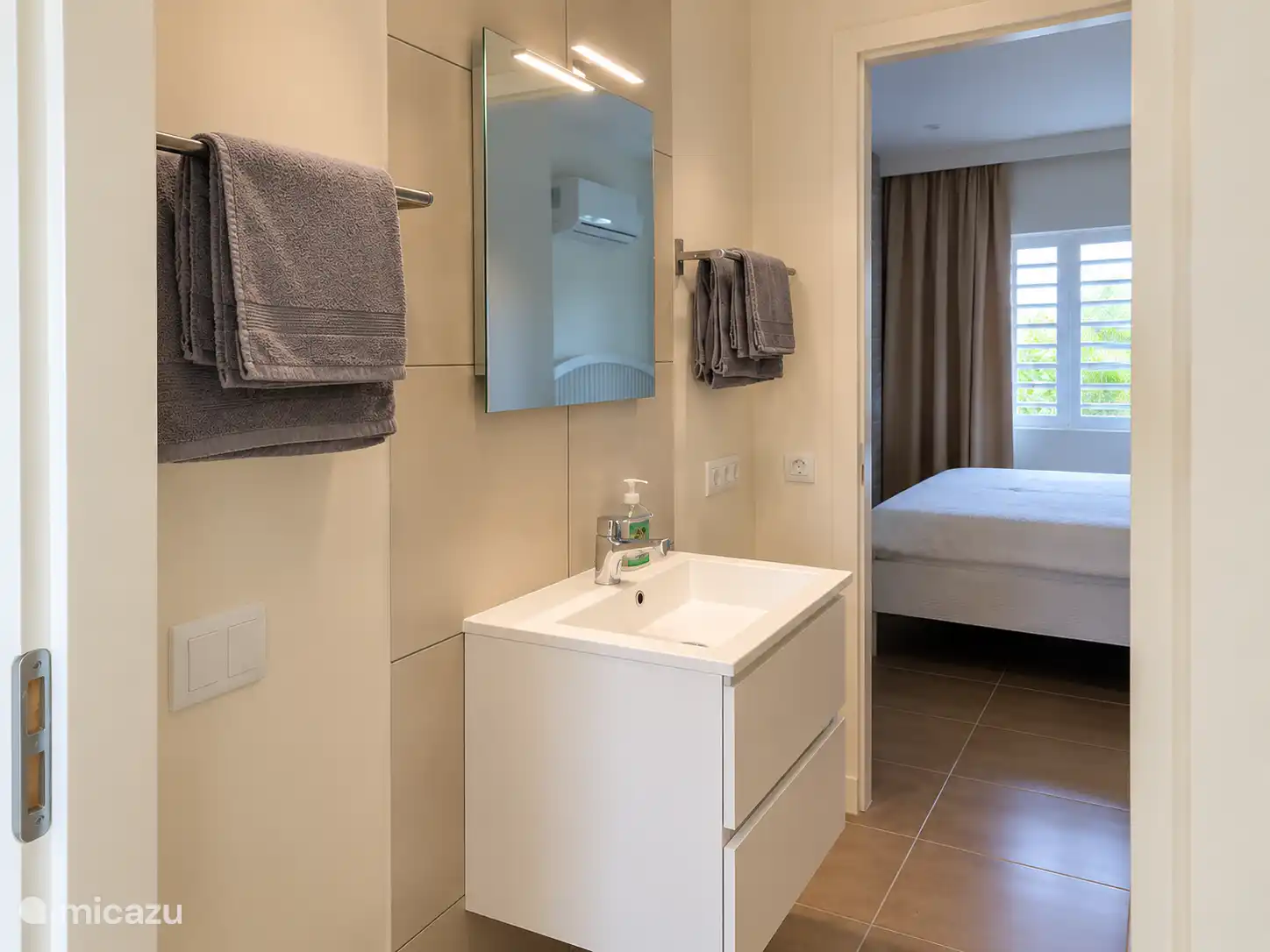 Salle de bain bien rangée avec une douche à l’italienne spacieuse, un lavabo et un espace de rangement. Il y a aussi une machine à laver, très pratique lors d’un séjour plus long à Curaçao.