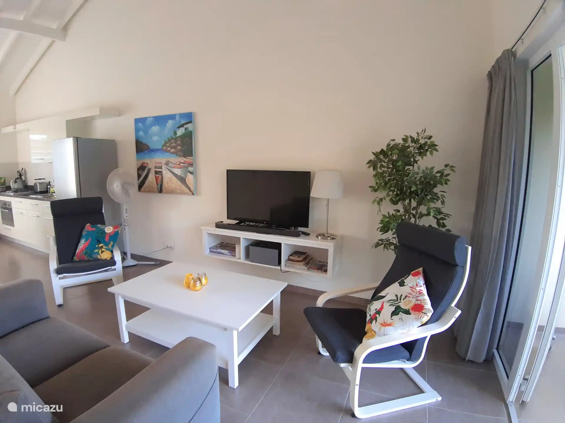 Un salon attrayant avec un canapé confortable à deux places et deux fauteuils séparés. Un endroit agréable pour s’asseoir ensemble, se détendre et profiter d’une soirée tranquille. 