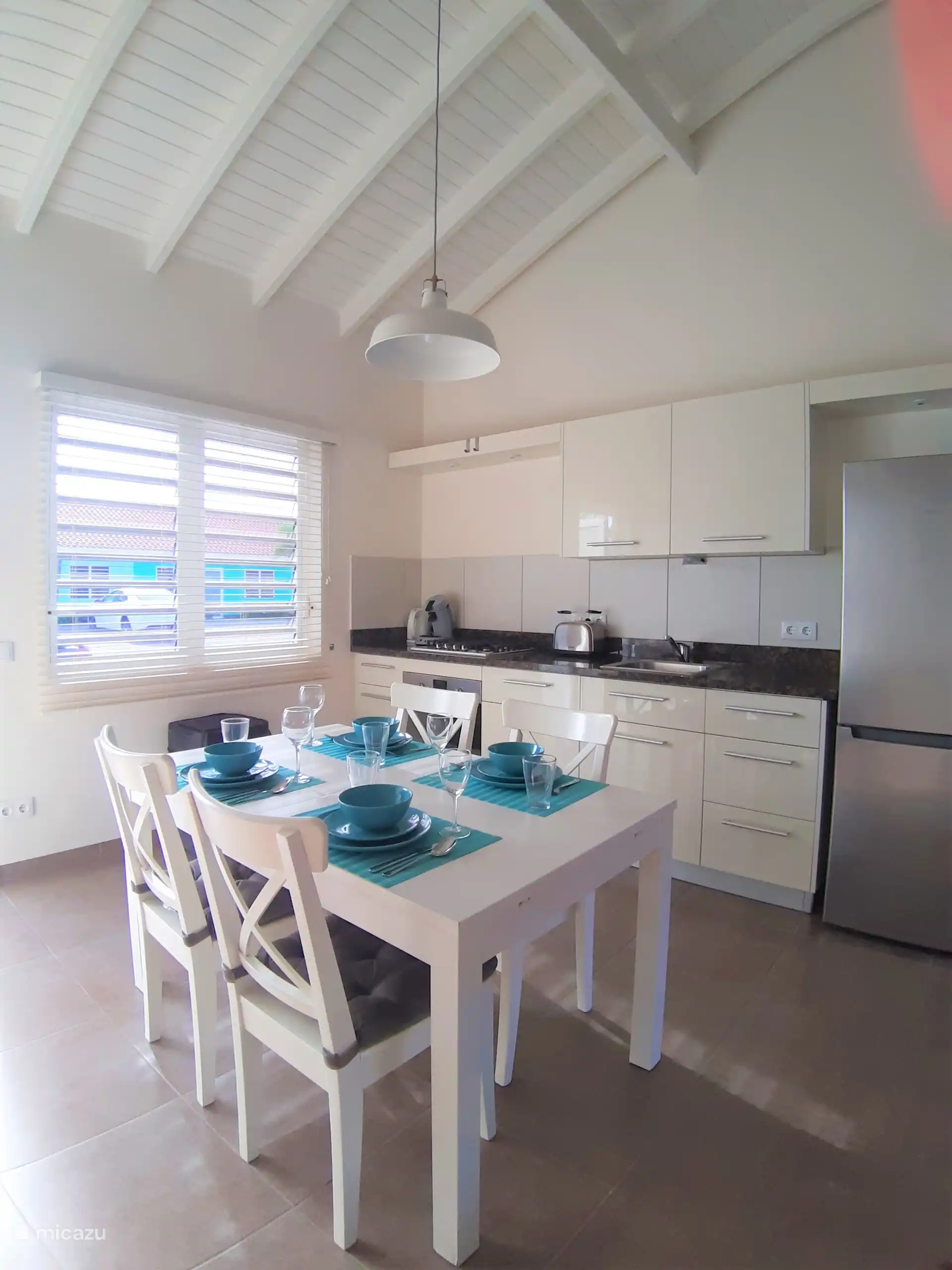 La cuisine ouverte avec un coin à manger douillet. La table est prête pour un petit-déjeuner, un déjeuner ou un dîner détendu pendant votre séjour à Curaçao. 