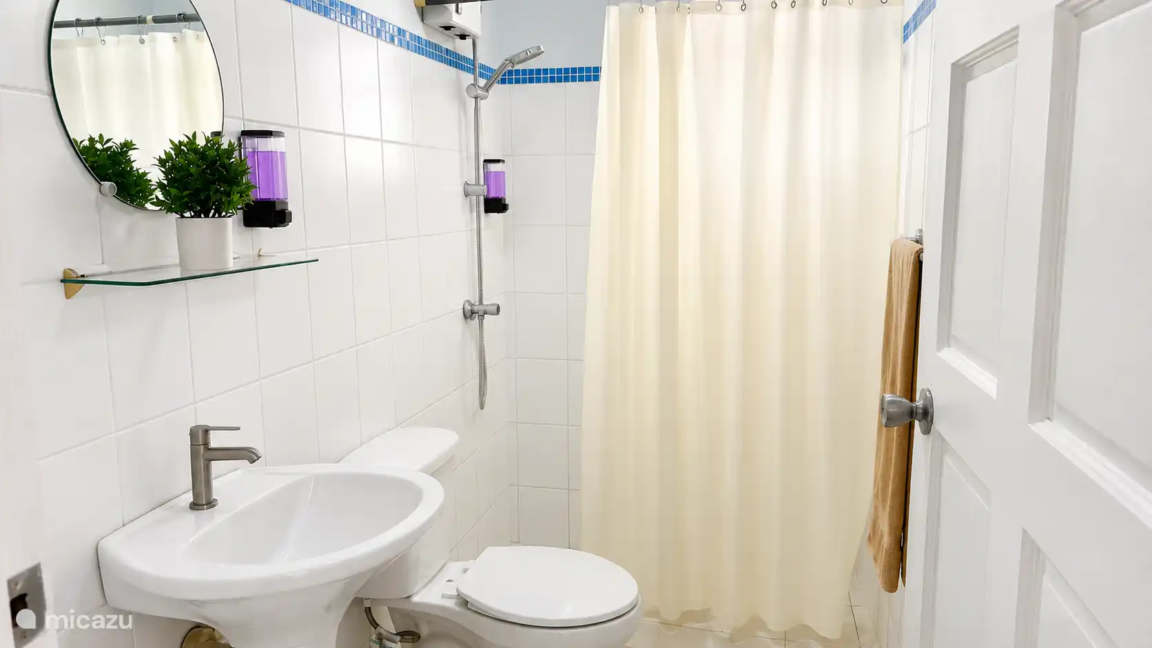 Nette en frisse badkamer met douche, toilet en wastafel. Praktisch ingericht met voldoende ruimte en voorzien van alles wat je nodig hebt voor een comfortabel verblijf.