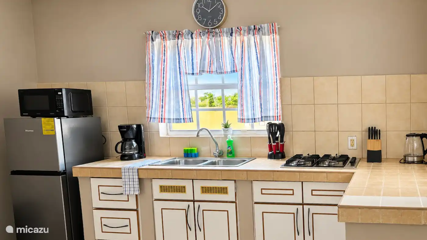 Volledig uitgeruste keuken met kookplaat, koffiezetapparaat, waterkoker en alle benodigdheden om zelf te koken. Praktisch en netjes ingericht.