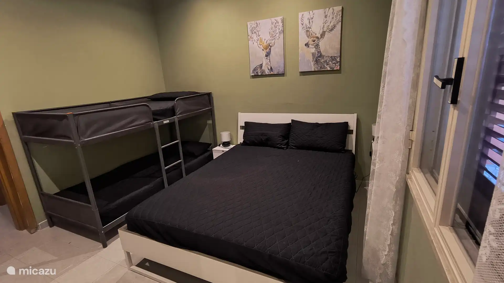 Slaapkamer met 2 persoonsbed en stapelbed.