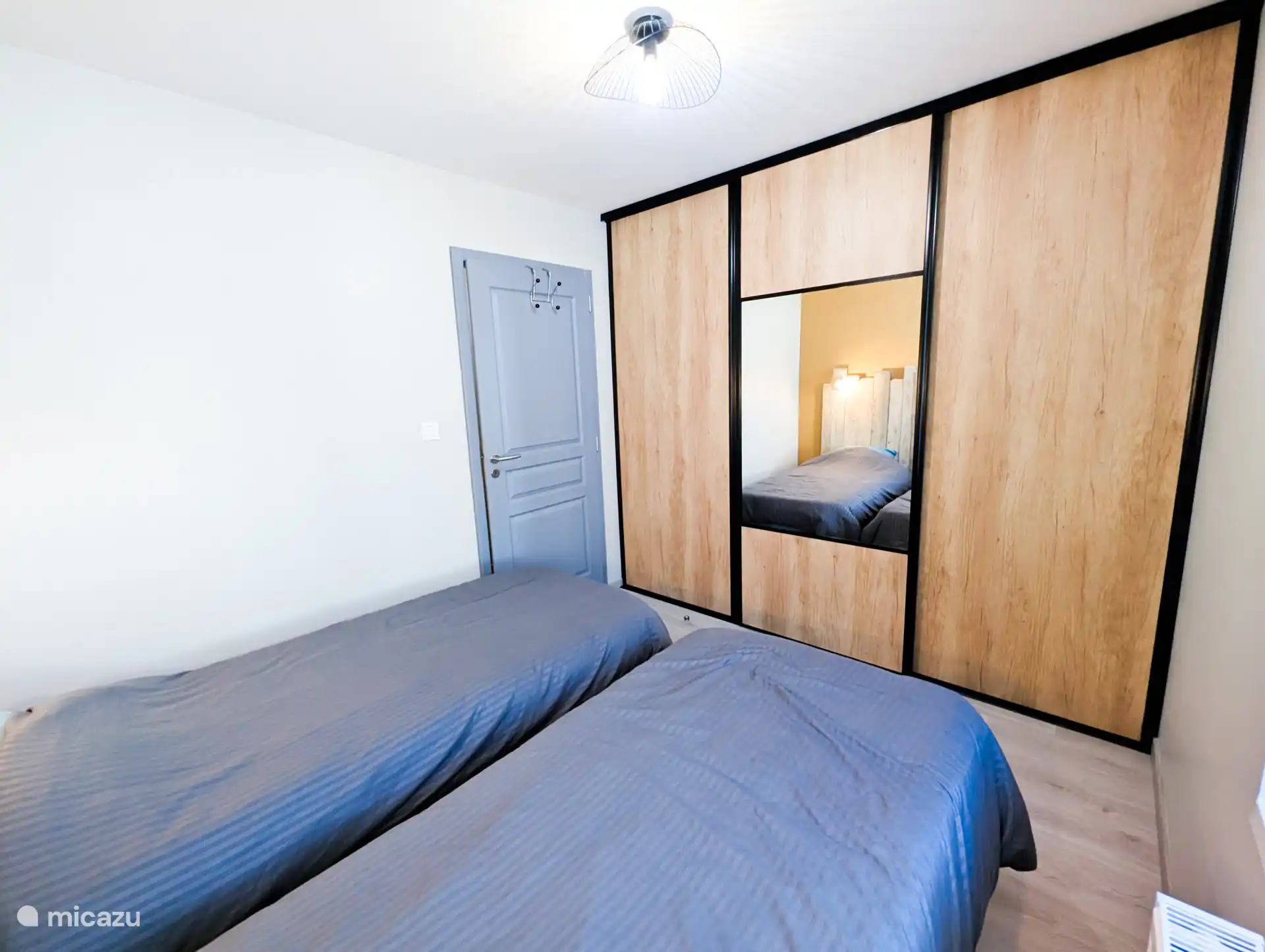 Slaapkamer met eenpersoonsbedden en opbergruimte
