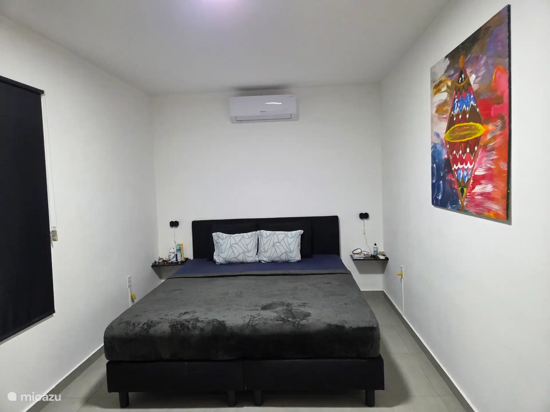 Geräumiges Schlafzimmer mit Doppelbett und Klimaanlage, Fernseher für eine angenehme Nachtruhe.