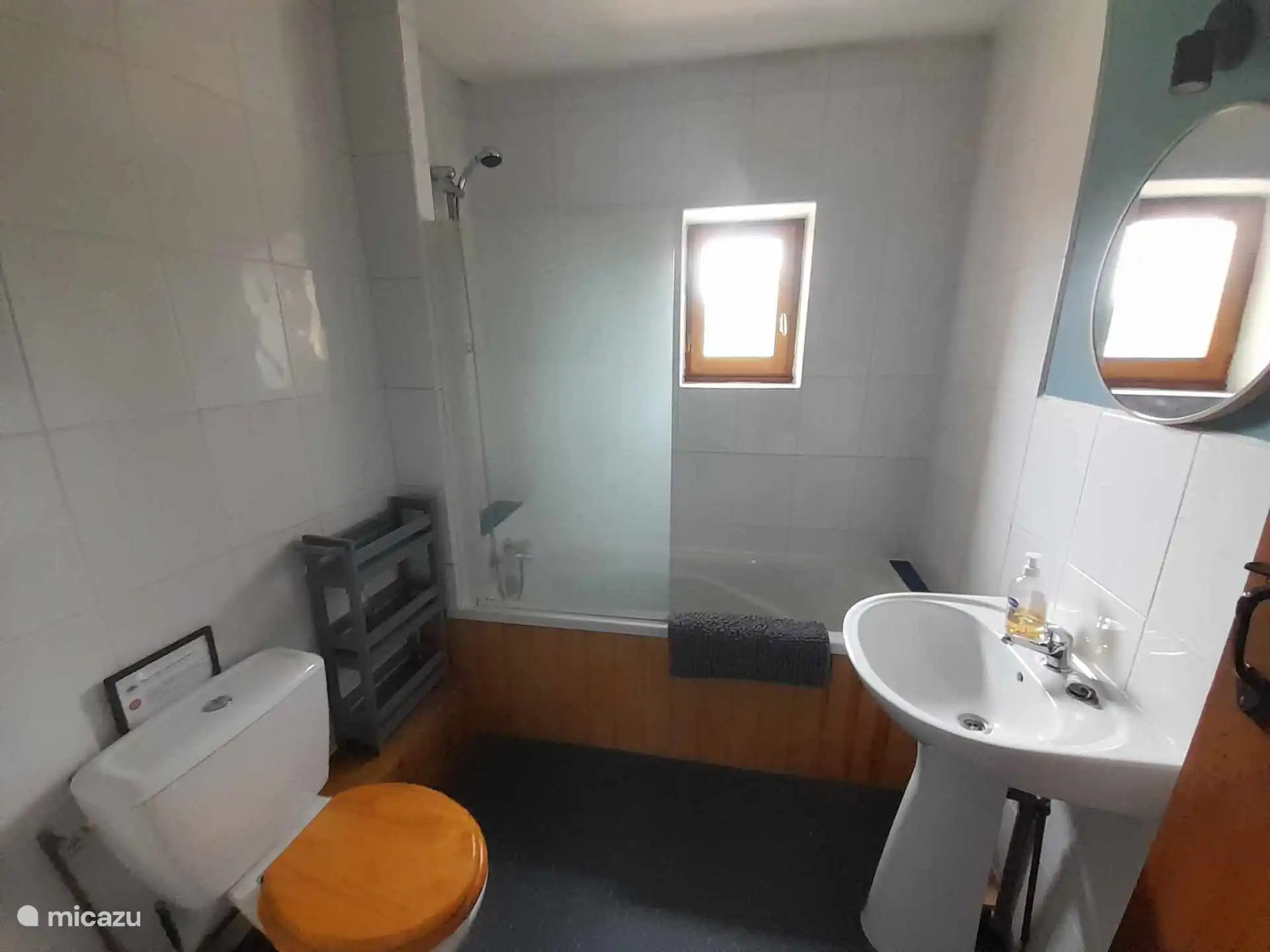 Badkamer met douche boven het bad. Een apart toilet is ook beschikbaar.
