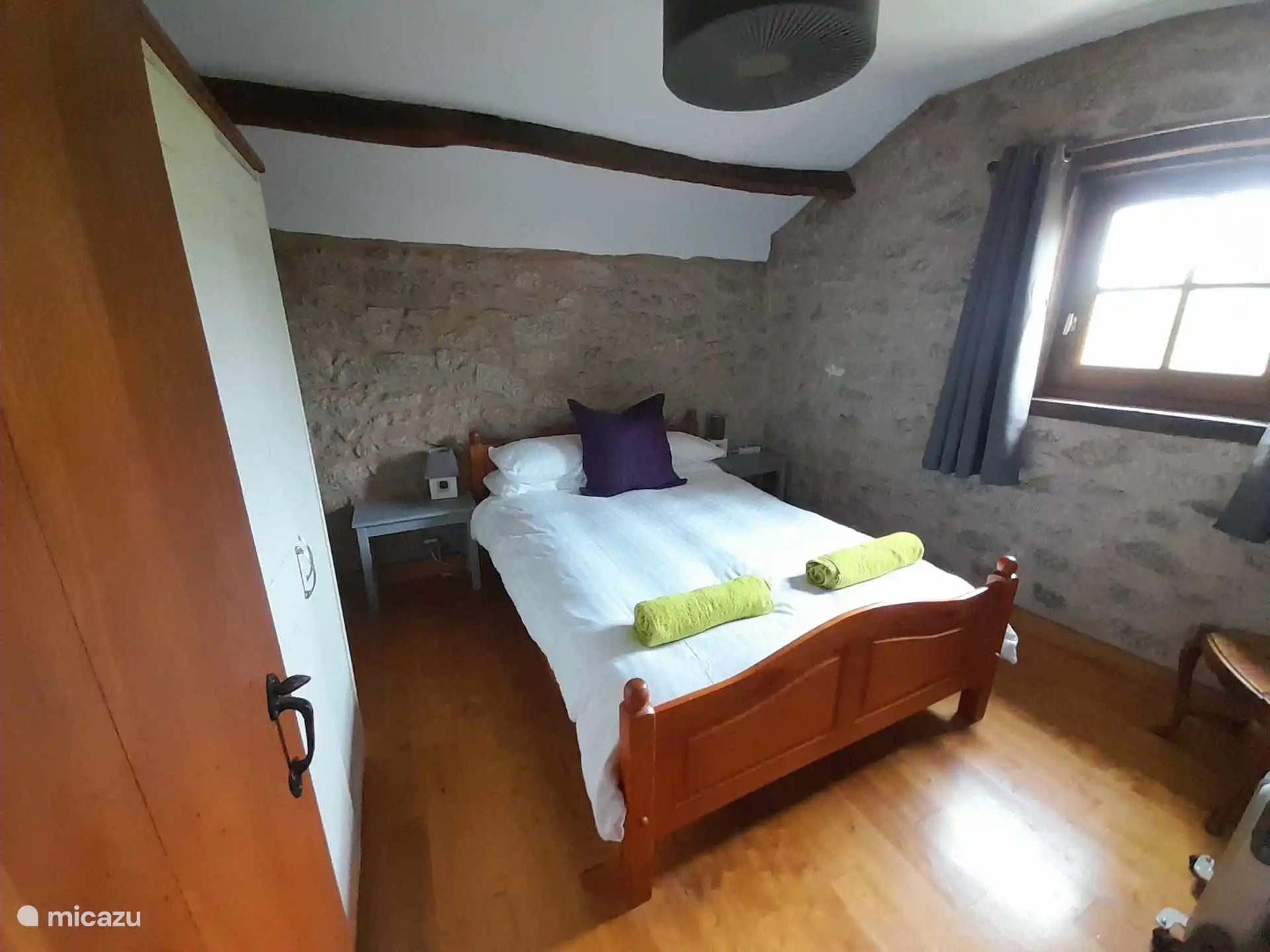 Comfortabele slaapkamer met tweepersoonsbed, kasten en lades.