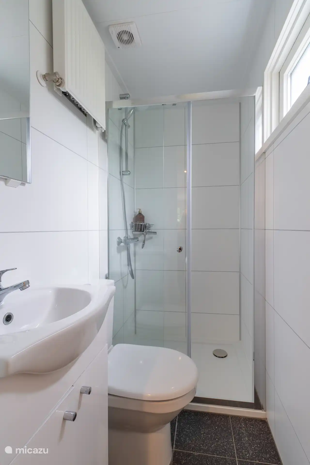 Moderne en complete badkamer met luxe douche en toilet.