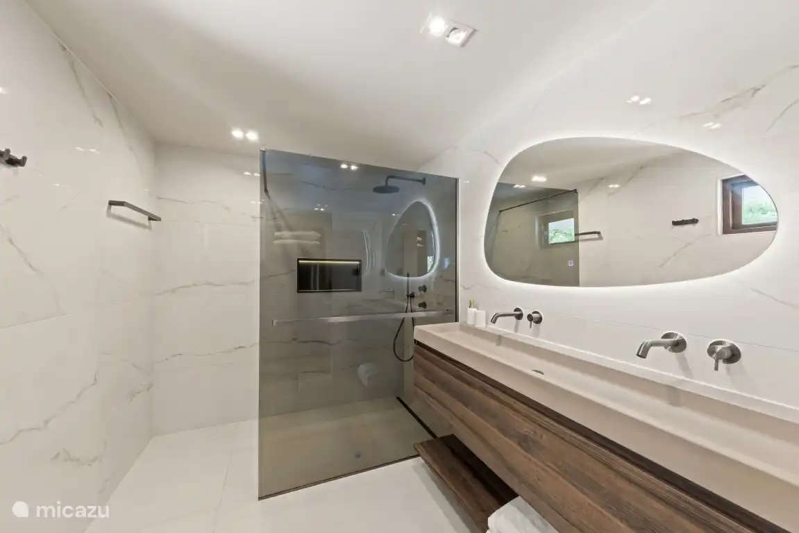 Baño del dormitorio 1 con ducha a pie de casa, ducha de lluvia/mano, lavandería y inodoro. Todos los baños tienen agua caliente y enchufes de 220 V. 