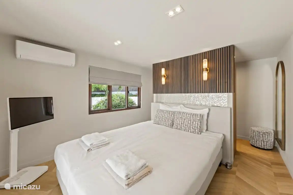 Dormitorio 1 (dormitorio principal) con cama king size (1,80x2,20 m), televisión y aire acondicionado. Detrás de la cama hay un armario, una caja fuerte y un baño privado en suite. 