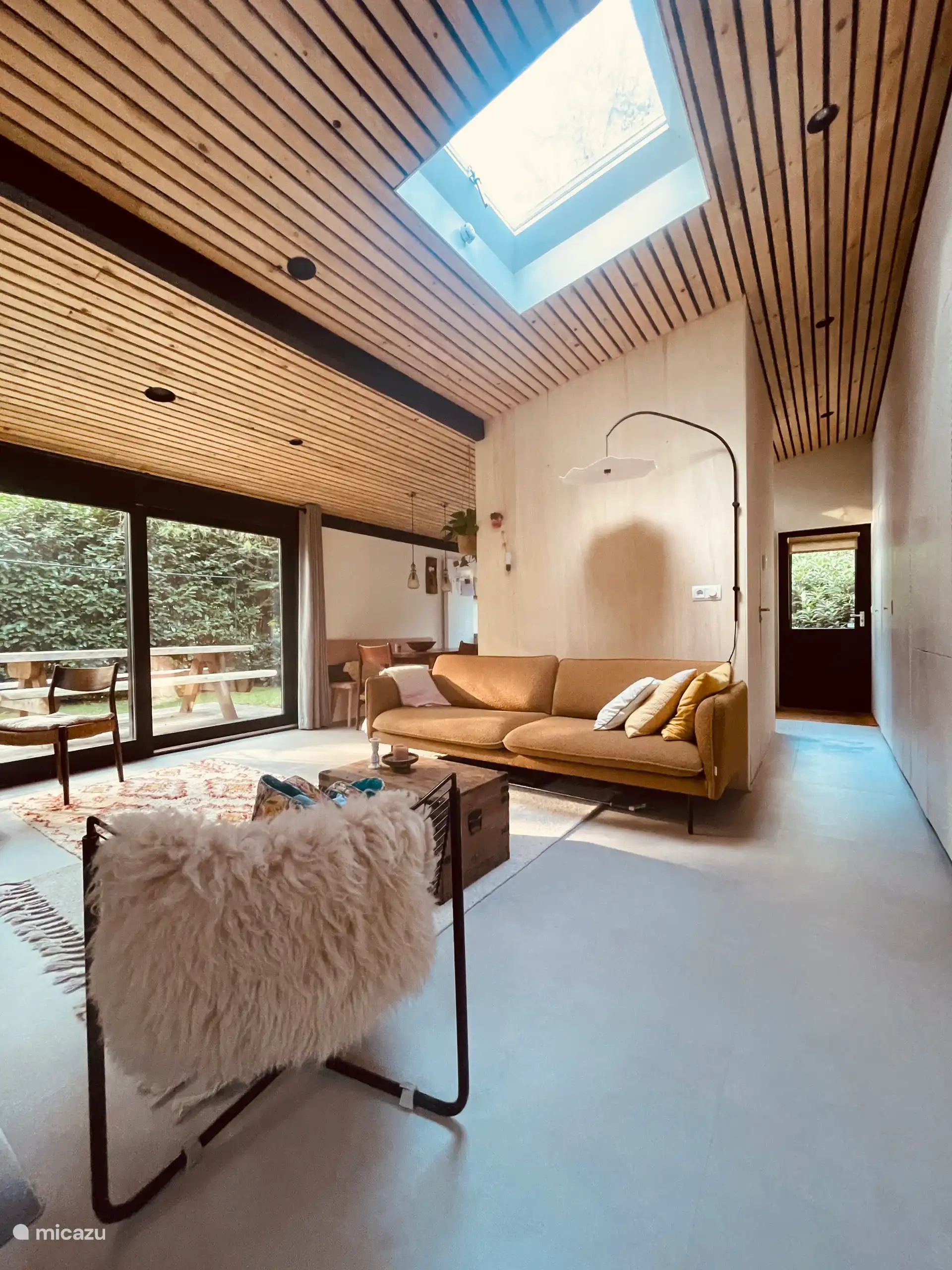Resumen del salón y el estilo original de este bungalow con una consola central que alberga el baño.