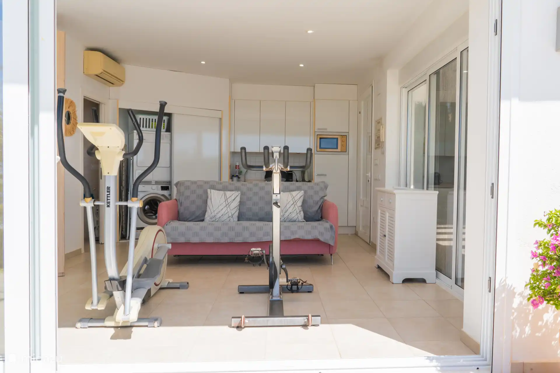 Kleines Studio mit Sportausrüstung und Waschküche.