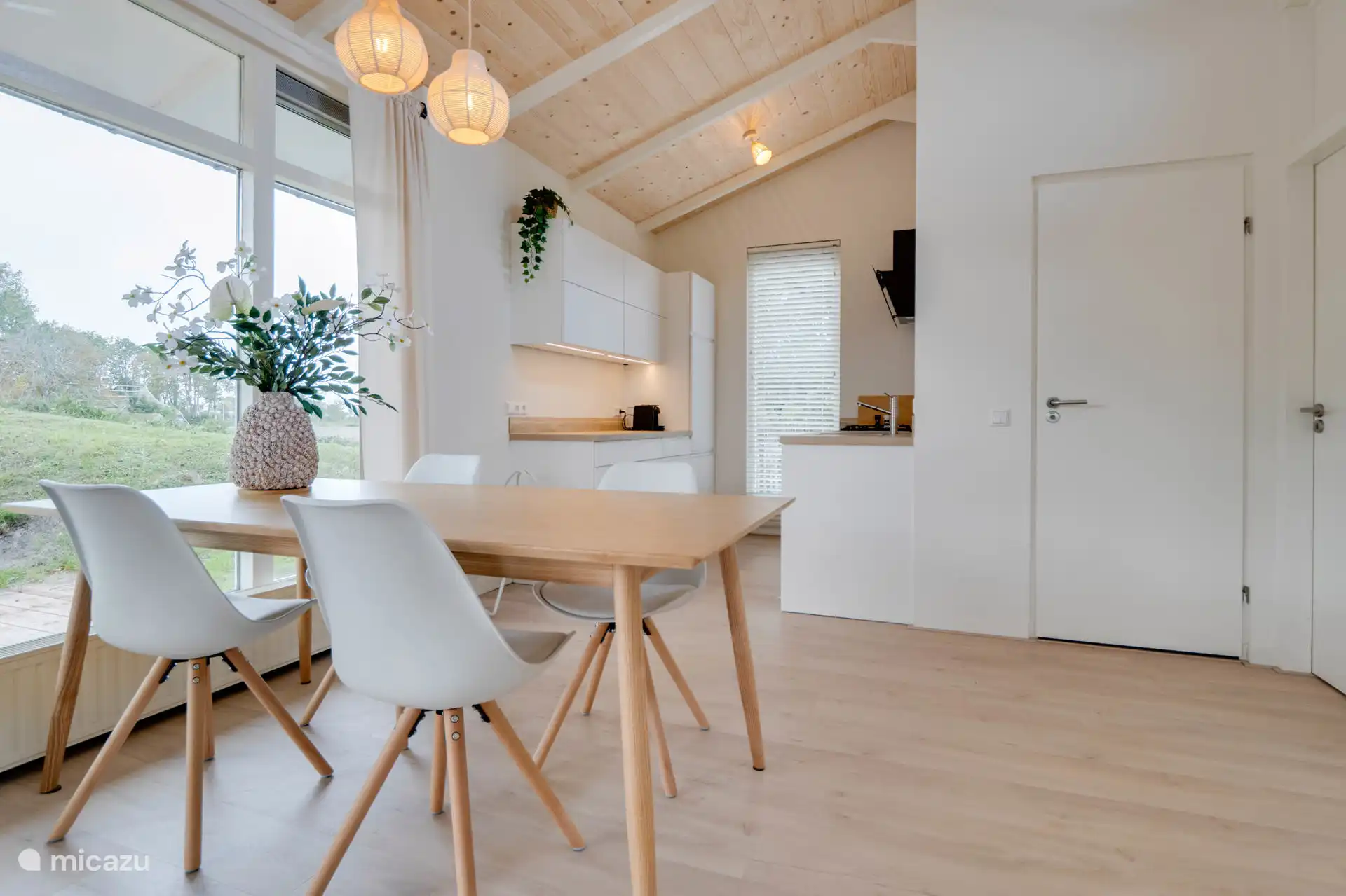 Table à manger et cuisine avec vue dégagée sur les terres agricoles en direction des dunes d’Ouddorp