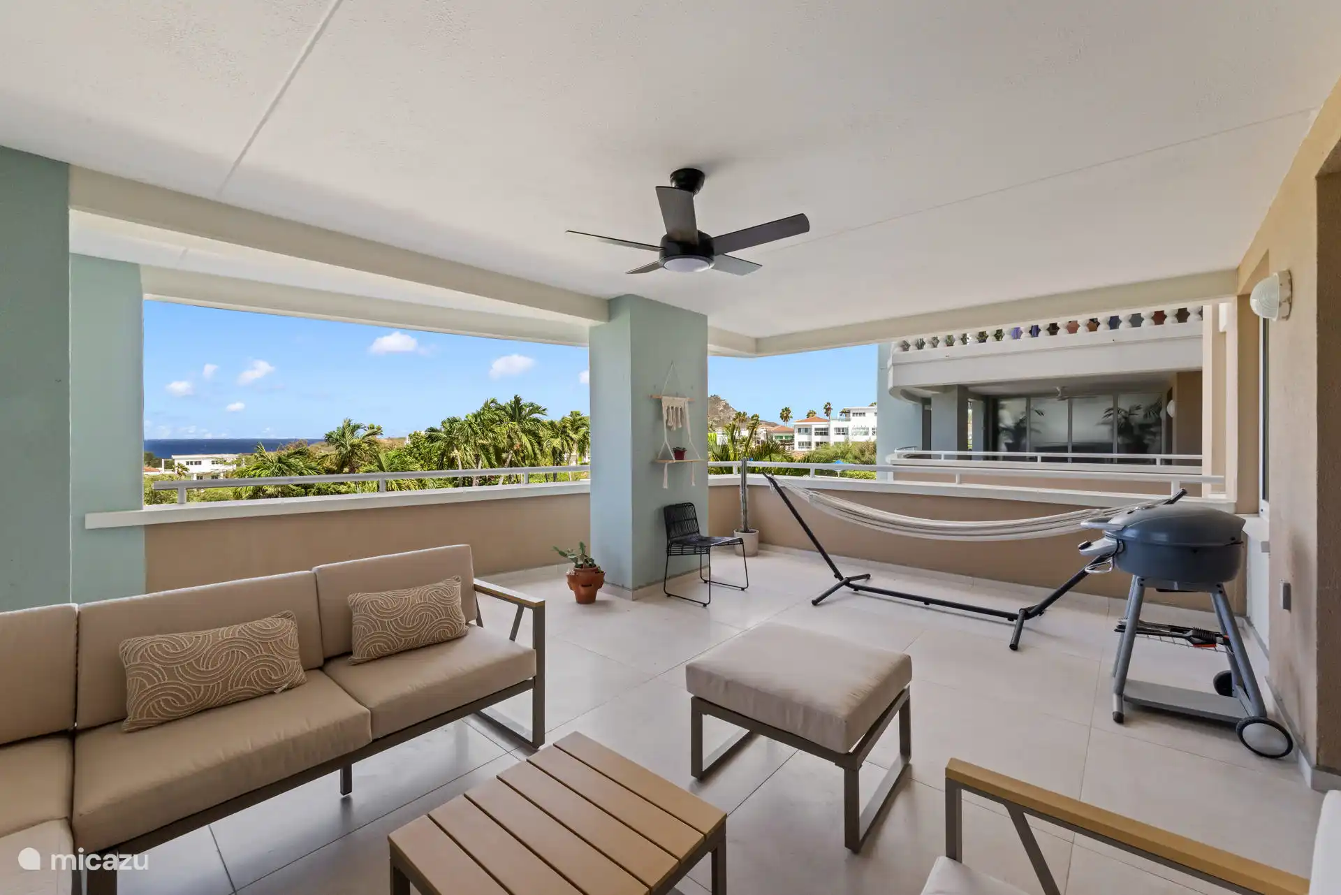 Het balkon met zeezicht, zicht op het zwembad, loungeset en bbq