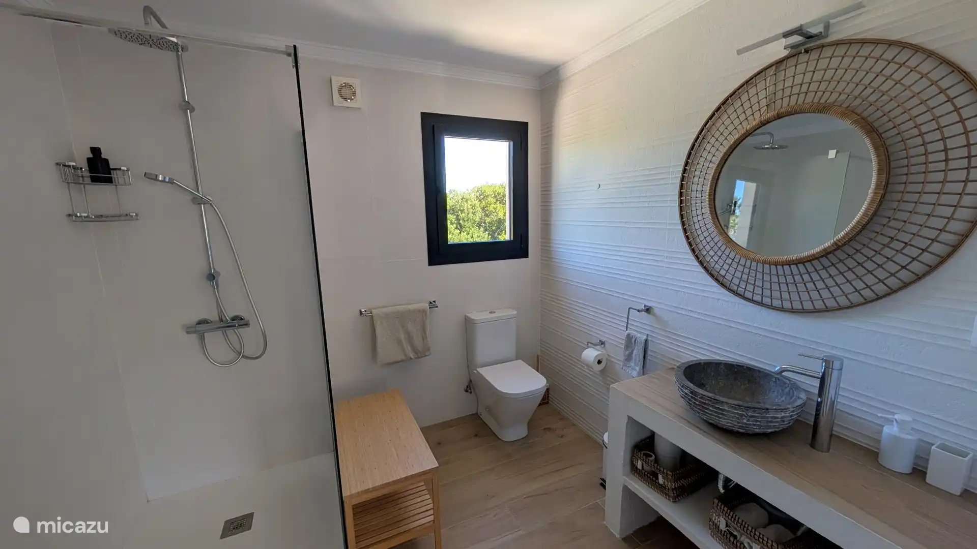 Badkamer met inloopdouche en stijlvolle stenen waskom. Na een dag in de zon fris je je hier heerlijk op.
