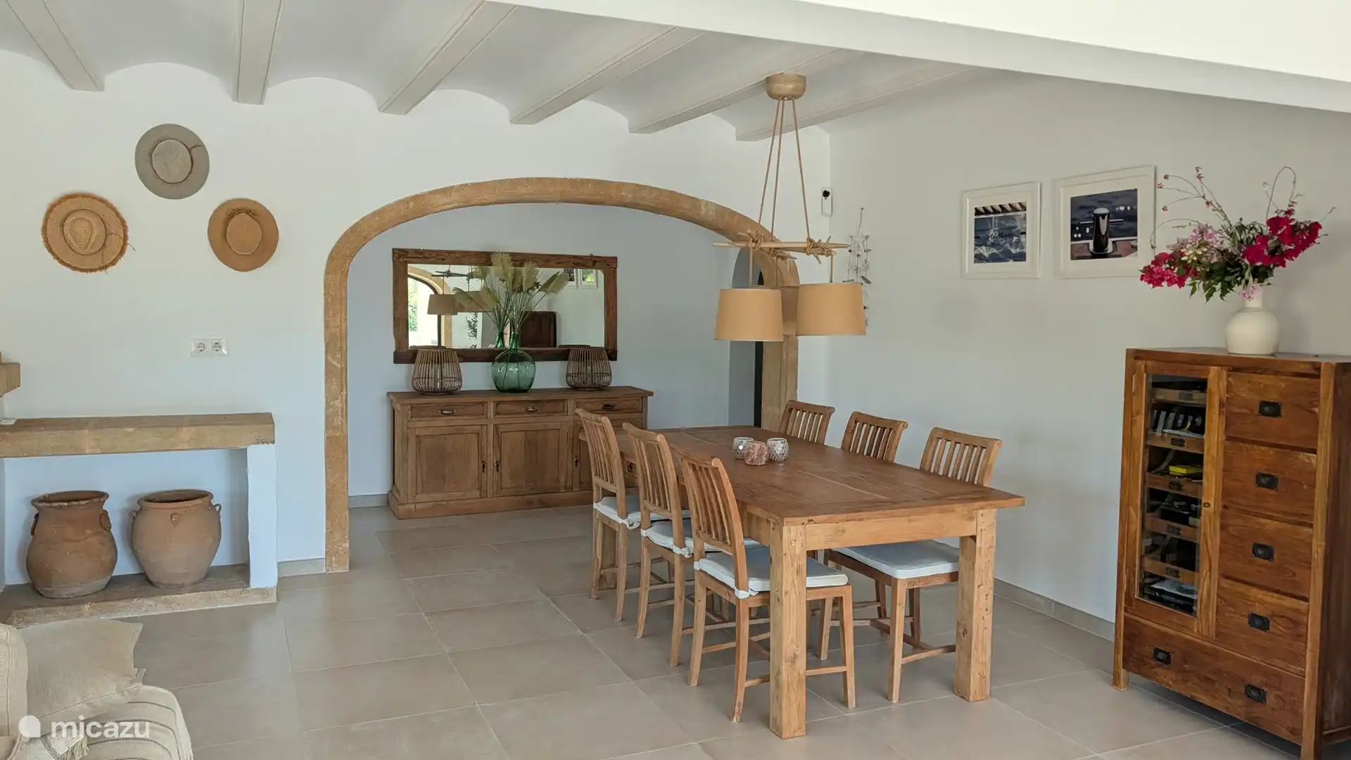 Eethoek met lange houten tafel onder de sfeervolle boog. Genoeg plek om met z'n allen aan tafel te schuiven.