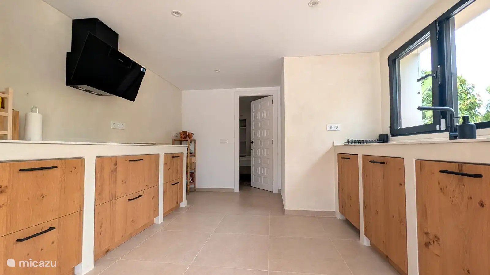 Keuken van het appartement met houten kastjes en een frisse, lichte uitstraling. Alles bij de hand om samen te koken tijdens je vakantie.