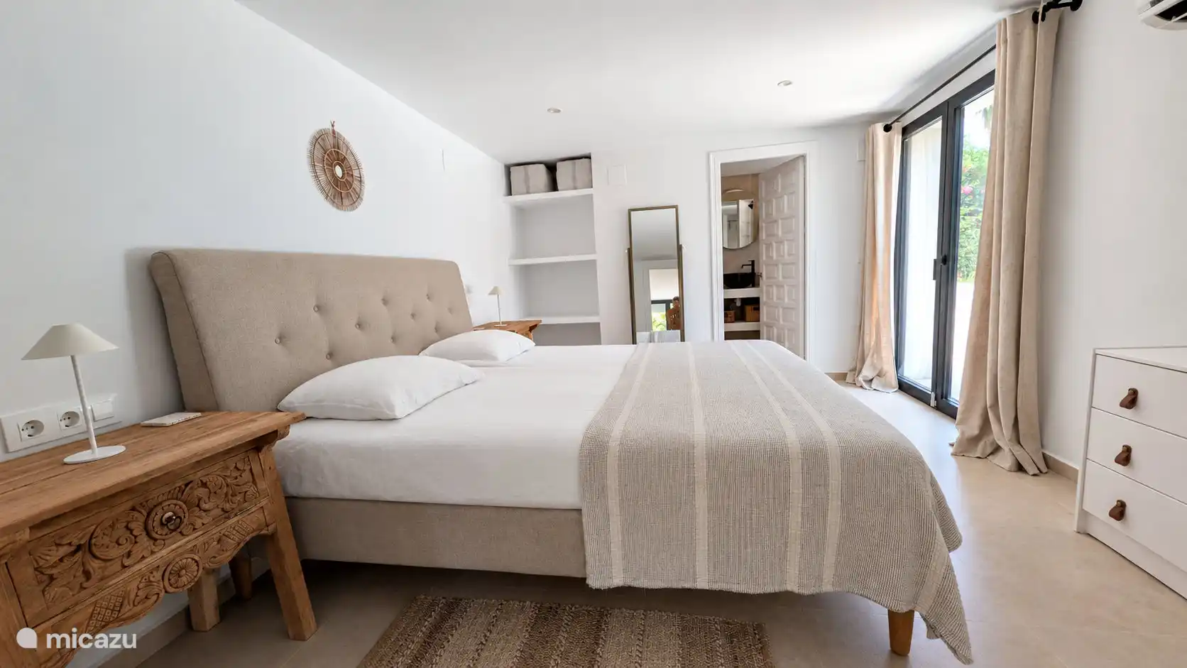 Slaapkamer met tweepersoonsbed en openslaande deuren naar buiten. 's Ochtends stap je zo vanuit bed de frisse buitenlucht in.