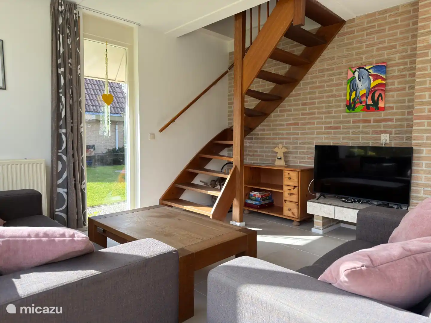 Woonkamer met tv en trap