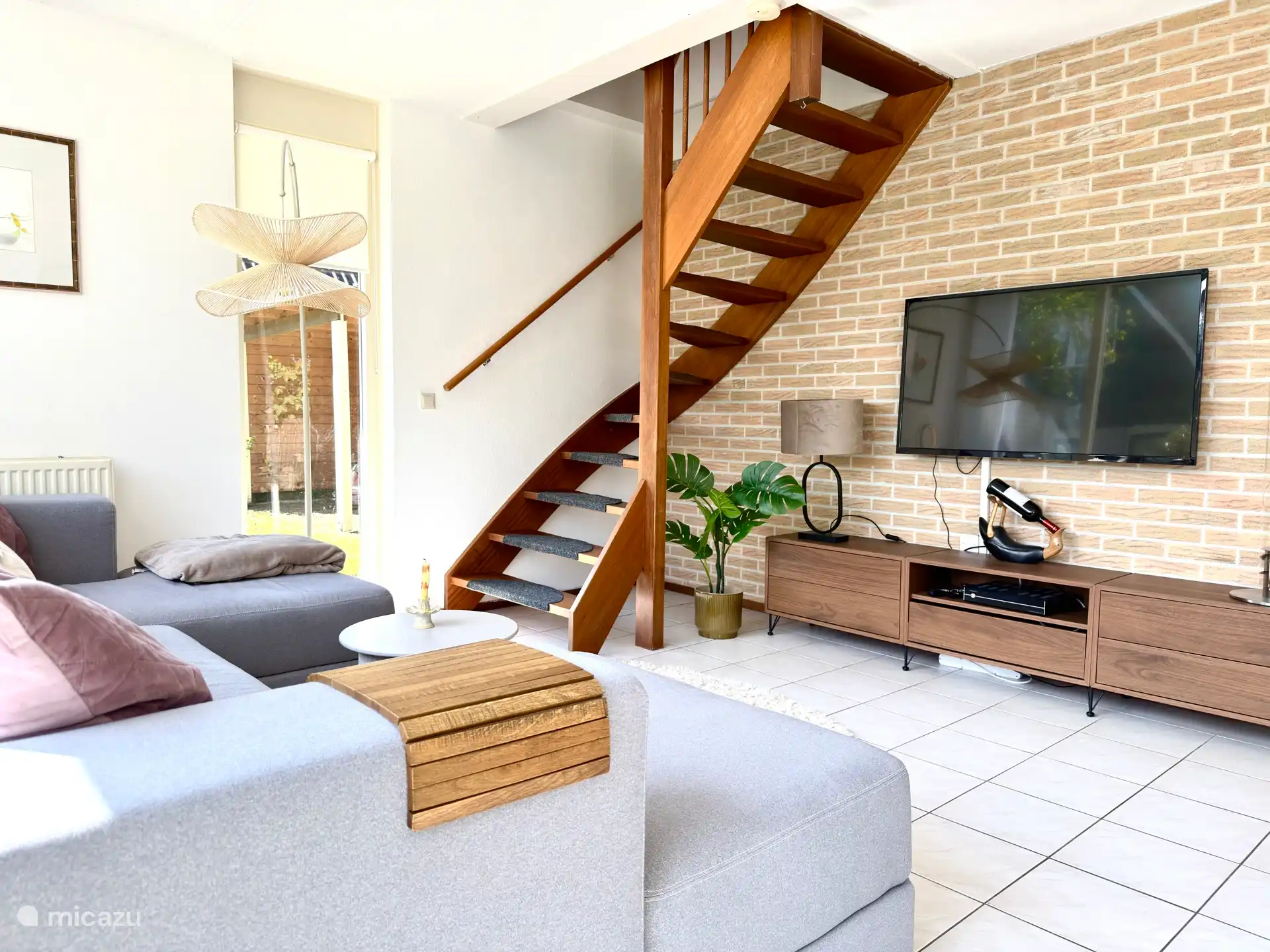 Woonkamer met tv en trap