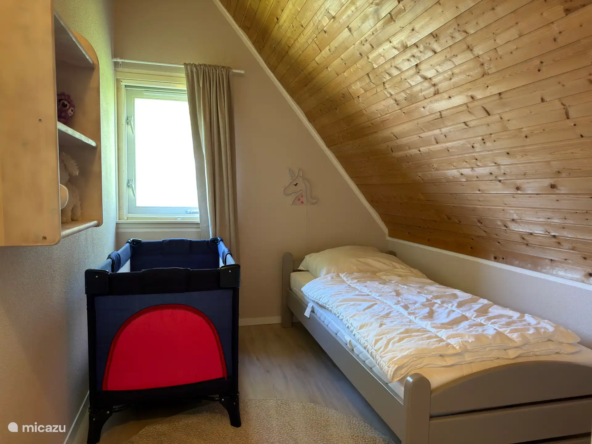 Slaapkamer met eenpersoonsbed en campingbedje