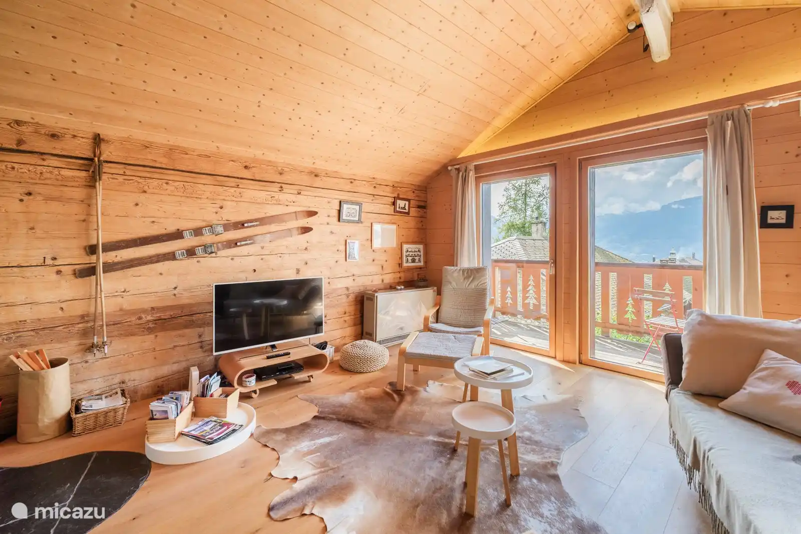 De lichte woonkamer met panoramisch uitzicht op de Alpen